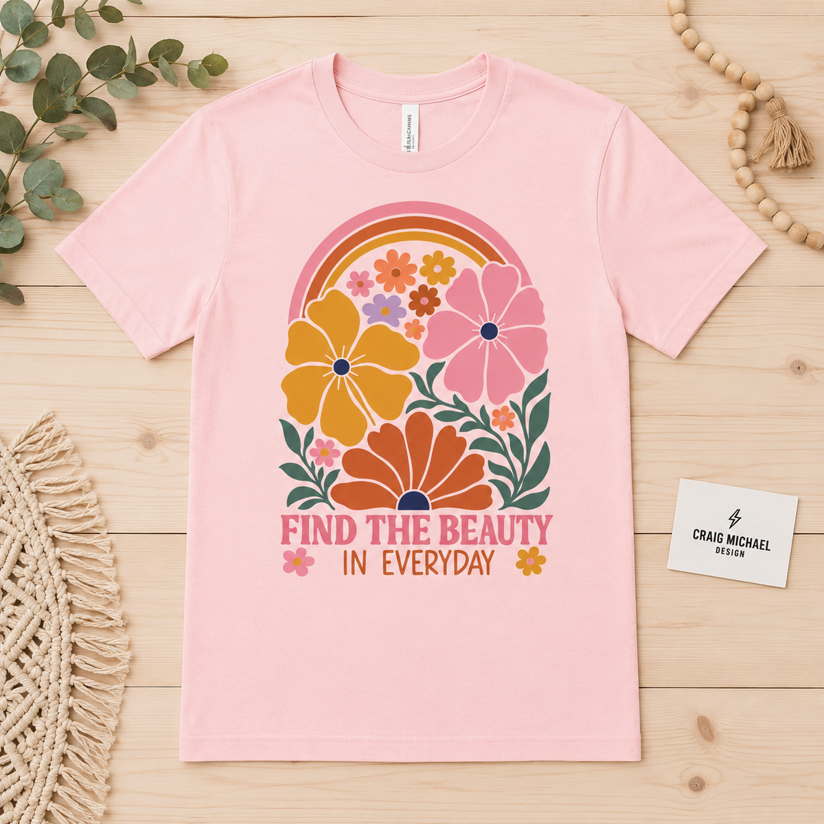 Pink t-shirt with retro floral design and text "FIND THE BEAUTY IN EVERYDAY".