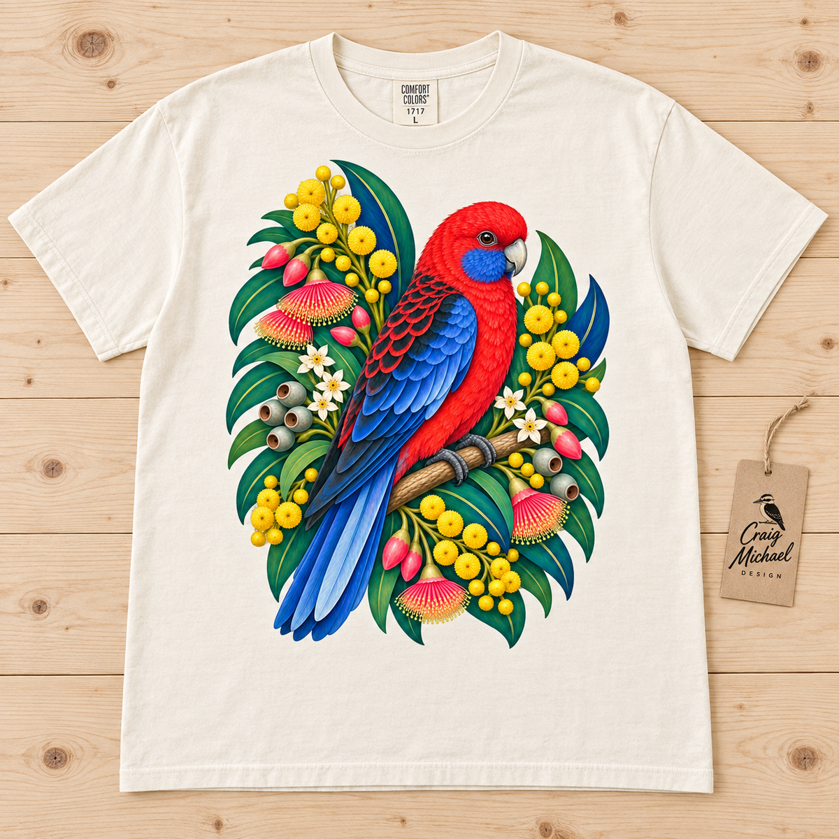 Cream t-shirt with a vibrant red and blue parrot perched on a branch surrounded by Australian flora.
