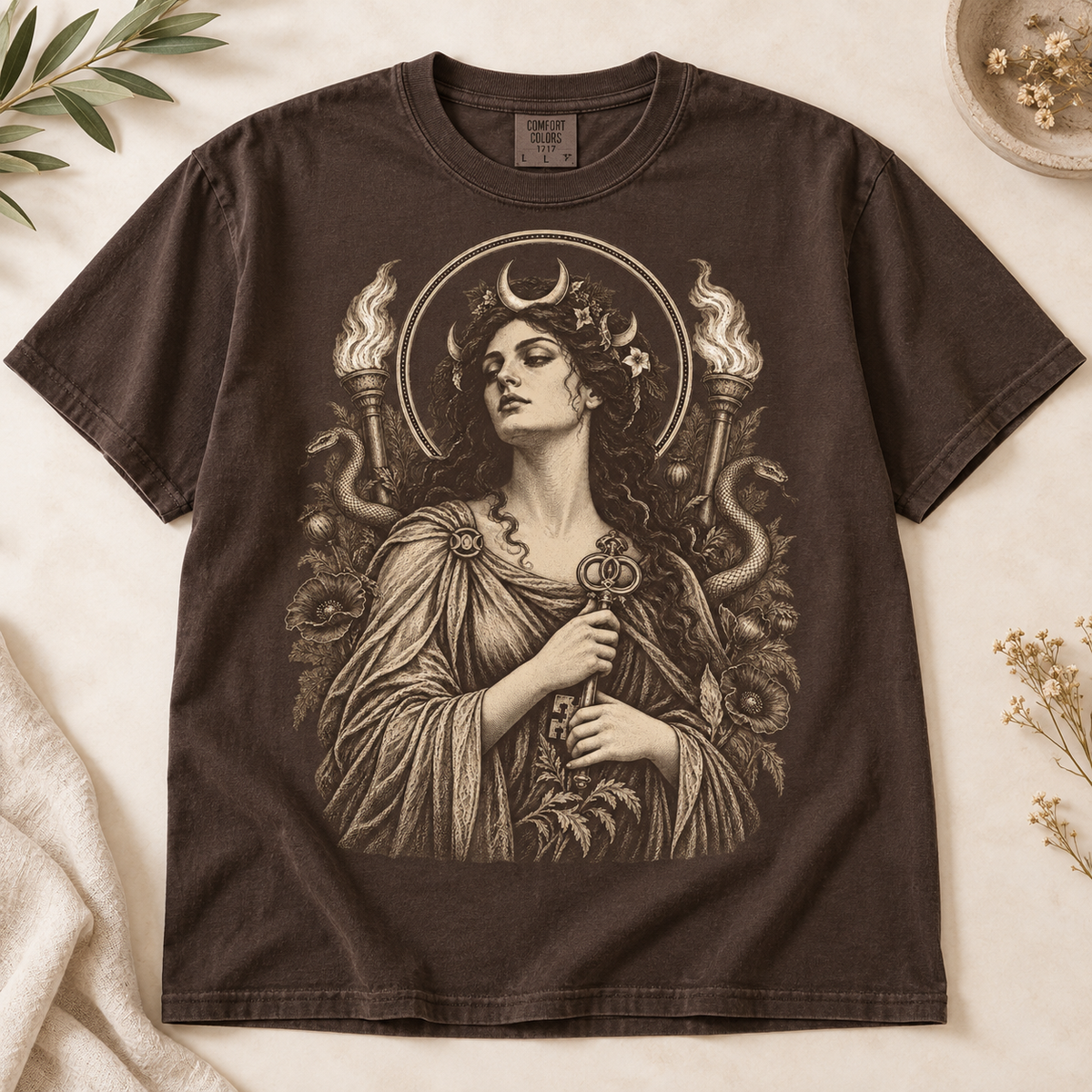 Dark brown t-shirt with a vintage-style graphic of a woman holding a key, surrounded by snakes and flames.