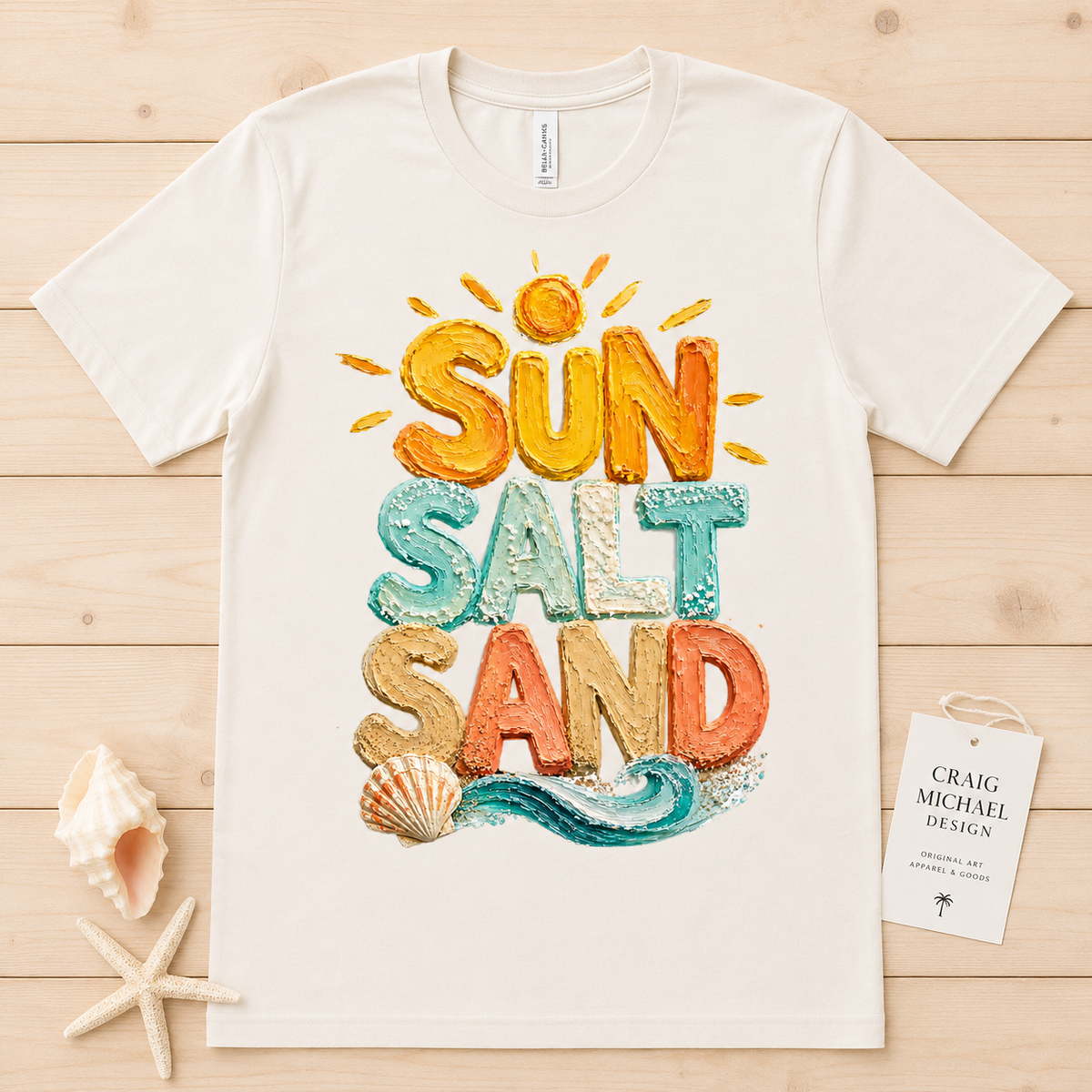 Cream t-shirt with textured "Sun Salt Sand" text and beach-themed illustration.