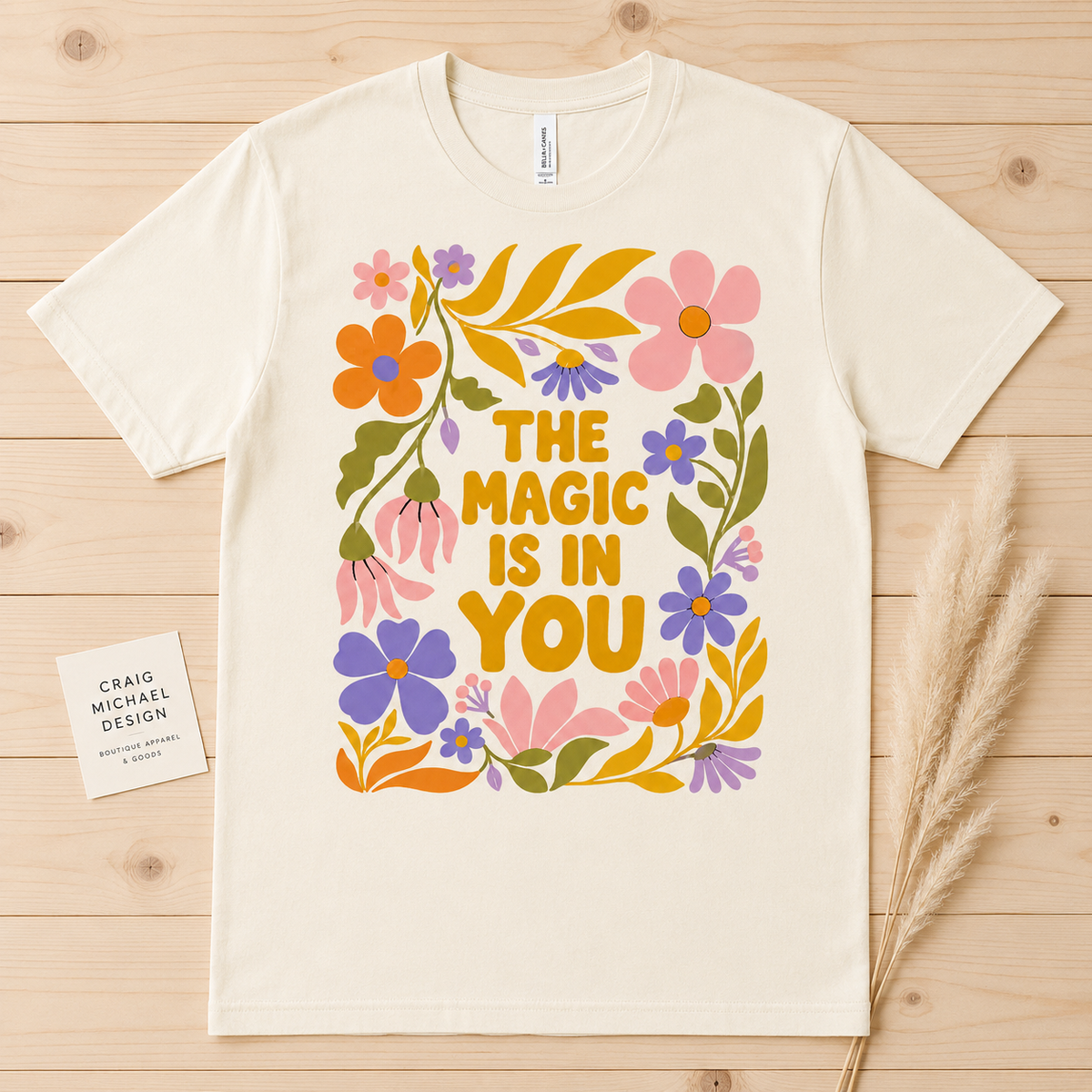 Cream t-shirt with colorful floral design and text "The Magic Is In You."
