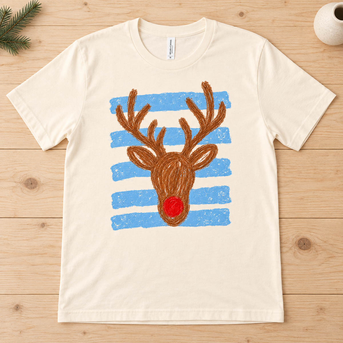 Cream t-shirt with a brown reindeer graphic and blue stripes.