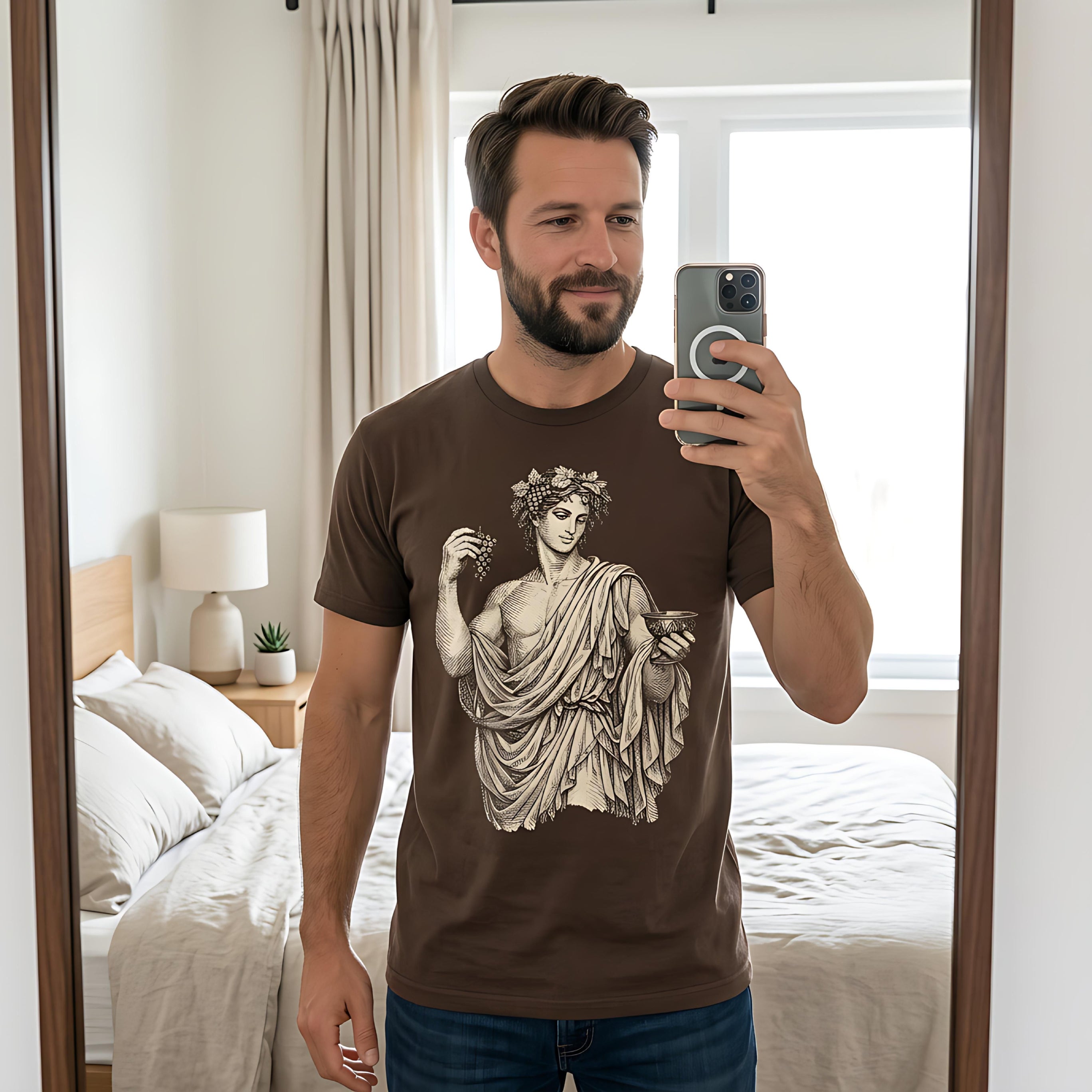 Man wearing brown t-shirt with Roman bust graphic, holding phone.