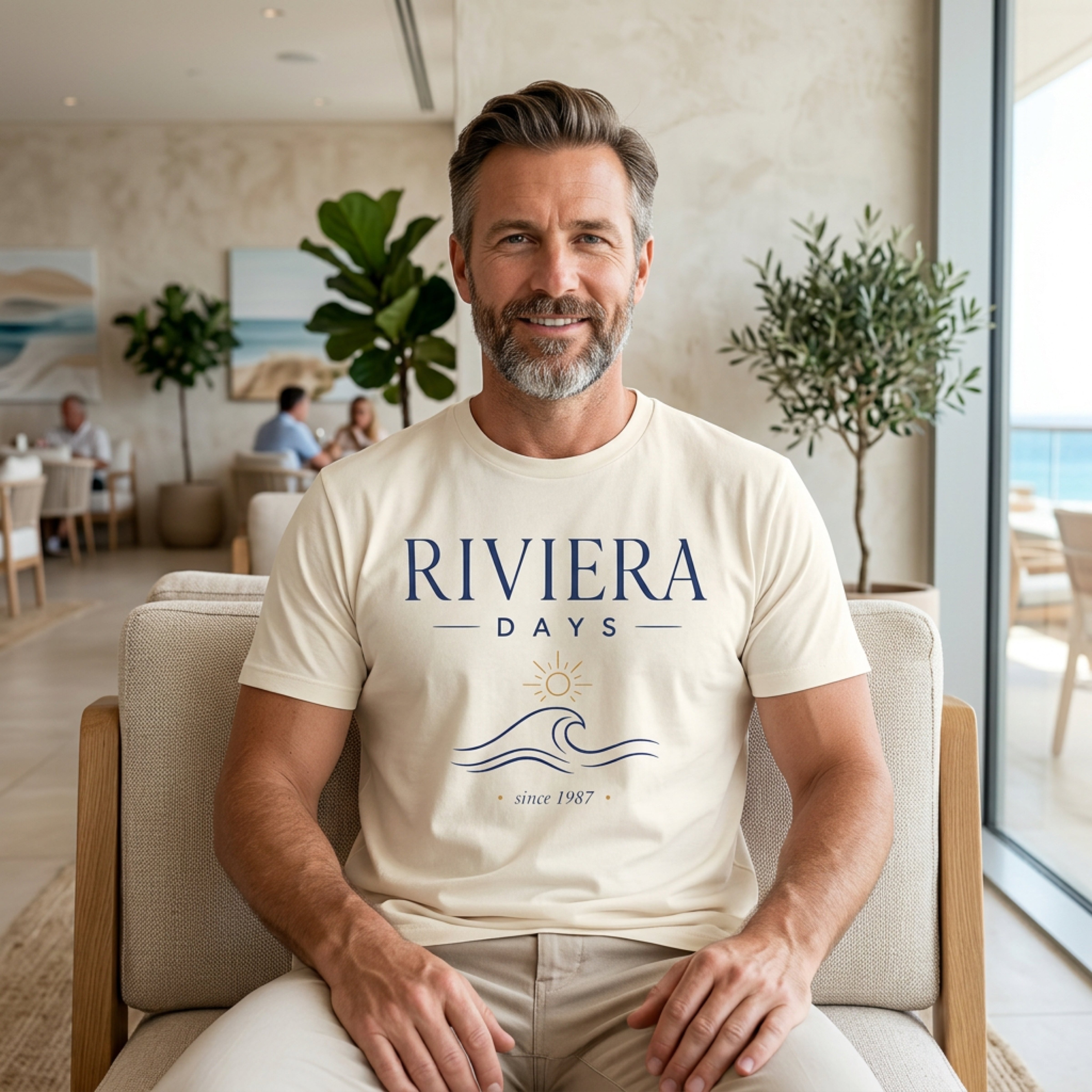 Man wearing cream t-shirt with "Riviera Days Since 1987" text and wavy sun logo.
