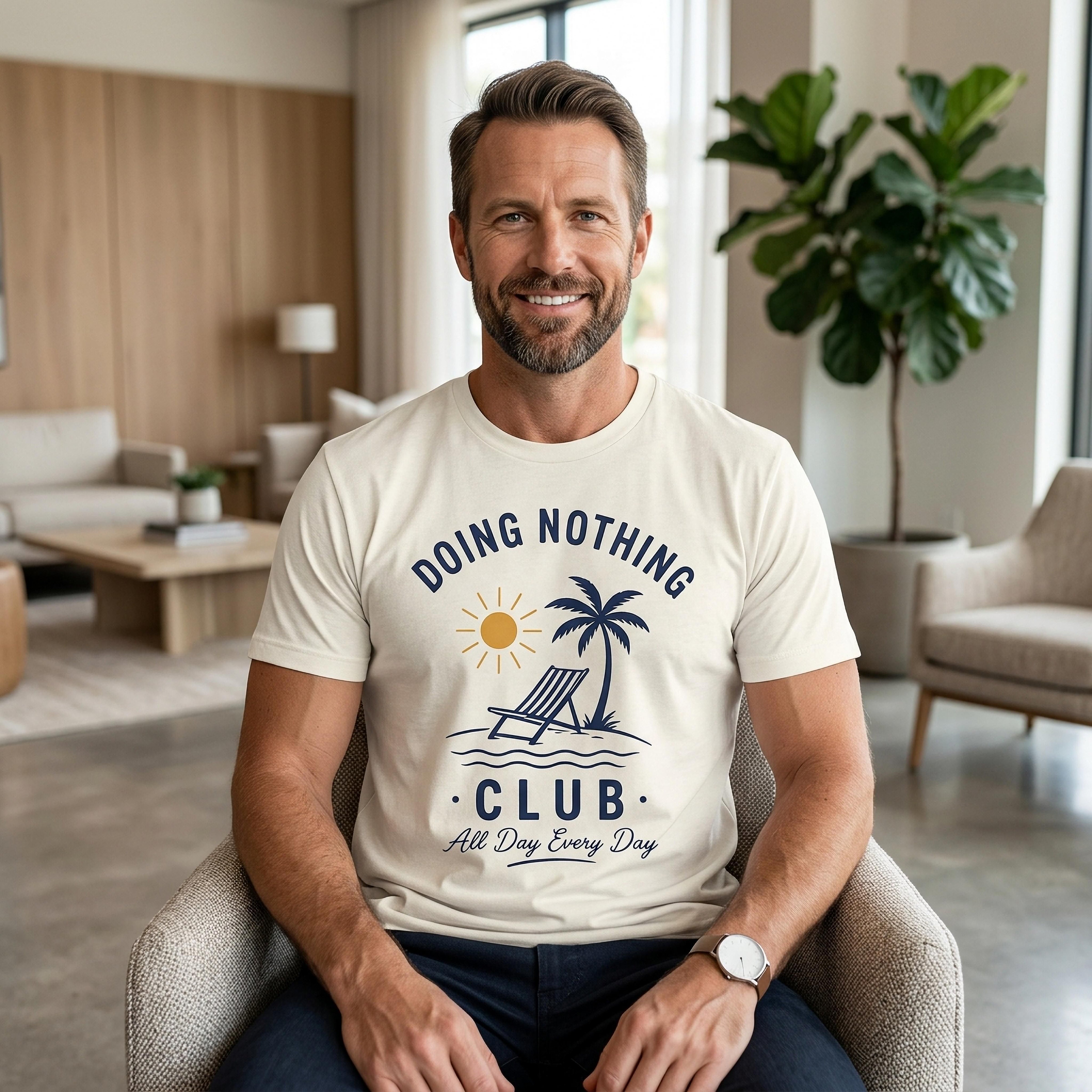 Man wearing cream t-shirt with "Doing Nothing Club" graphic and palm tree.