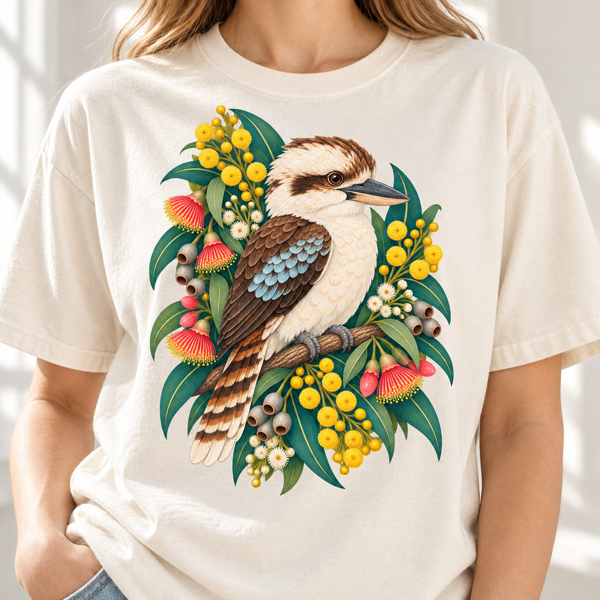 Kookaburra perched on a branch surrounded by eucalyptus leaves and flowers.