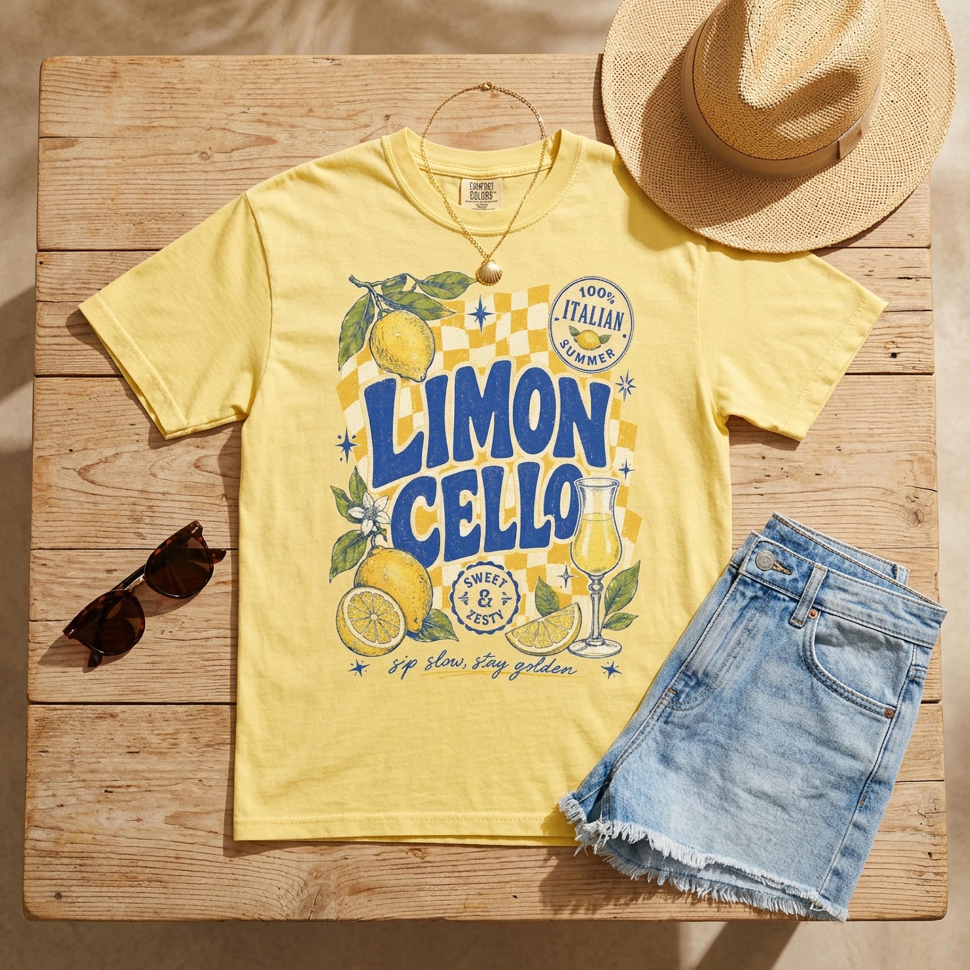 Yellow t-shirt with Limoncello graphic, denim shorts, sunglasses, and straw hat.