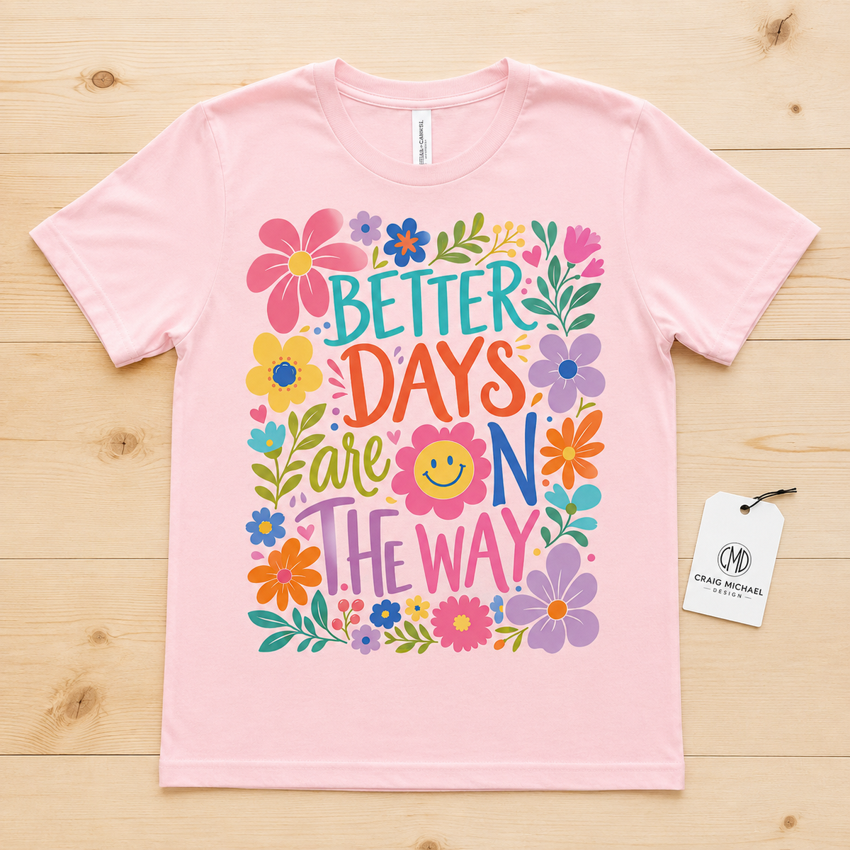 Pink t-shirt with colorful floral design and text "BETTER DAYS are ON THE WAY".