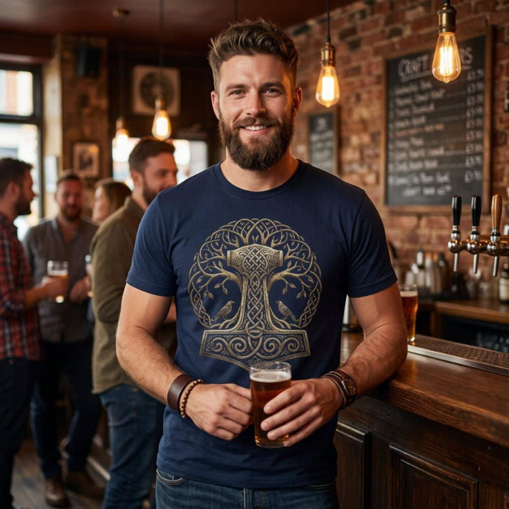 Man in navy t-shirt with golden Thor's Hammer design, holding beer.