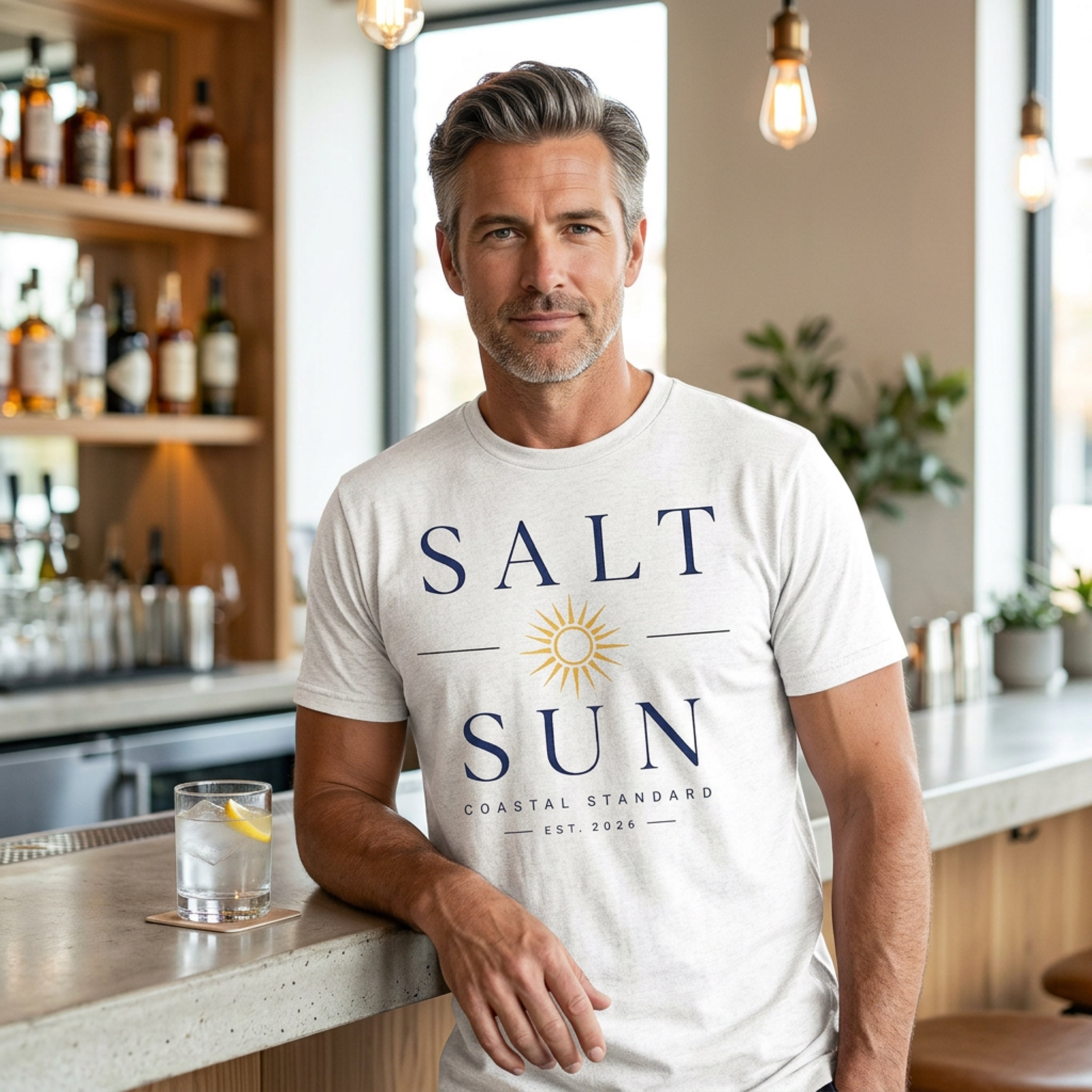 Man wearing a light gray t-shirt with "SALT SUN" and a sun graphic.