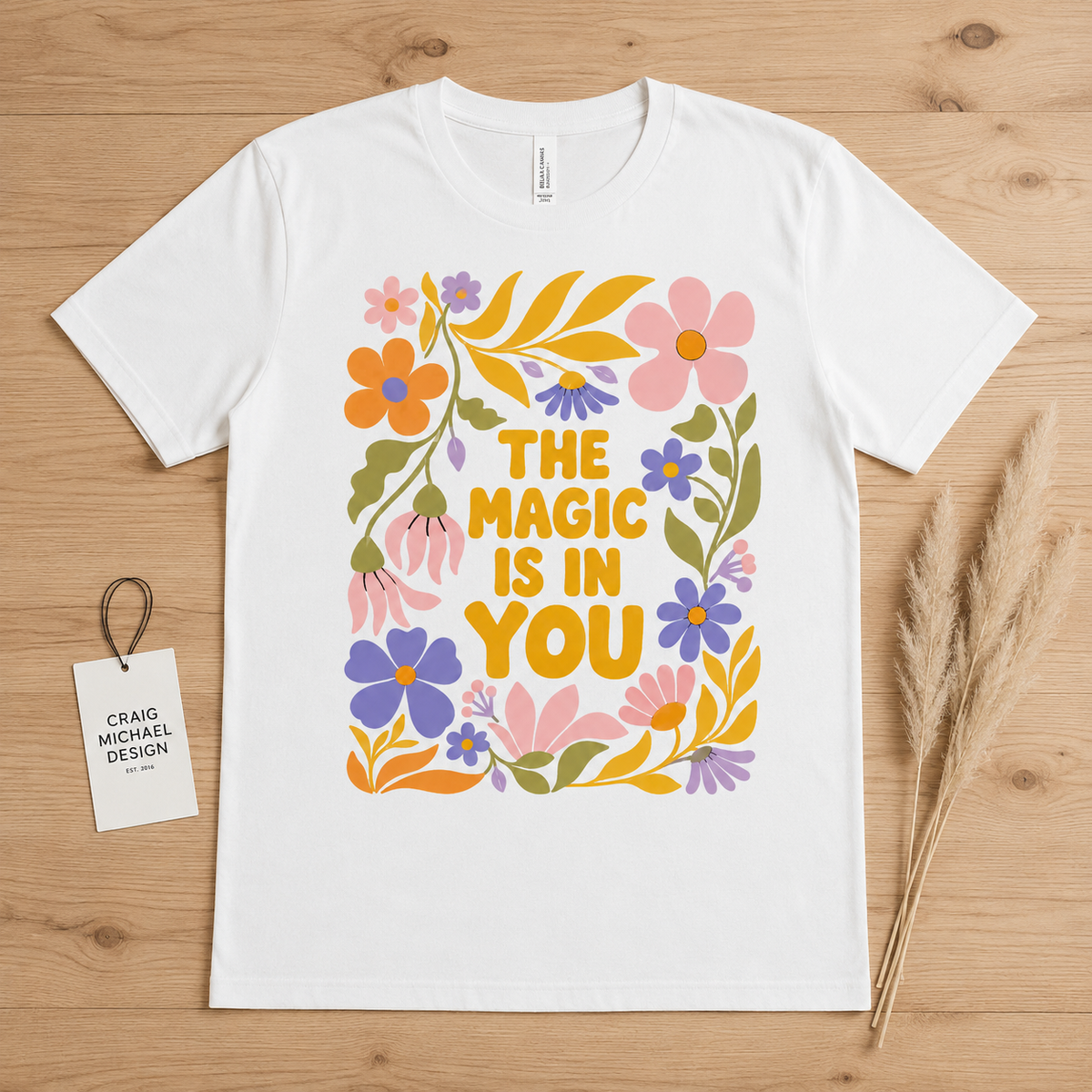 White t-shirt with "The Magic Is In You" text and floral design.
