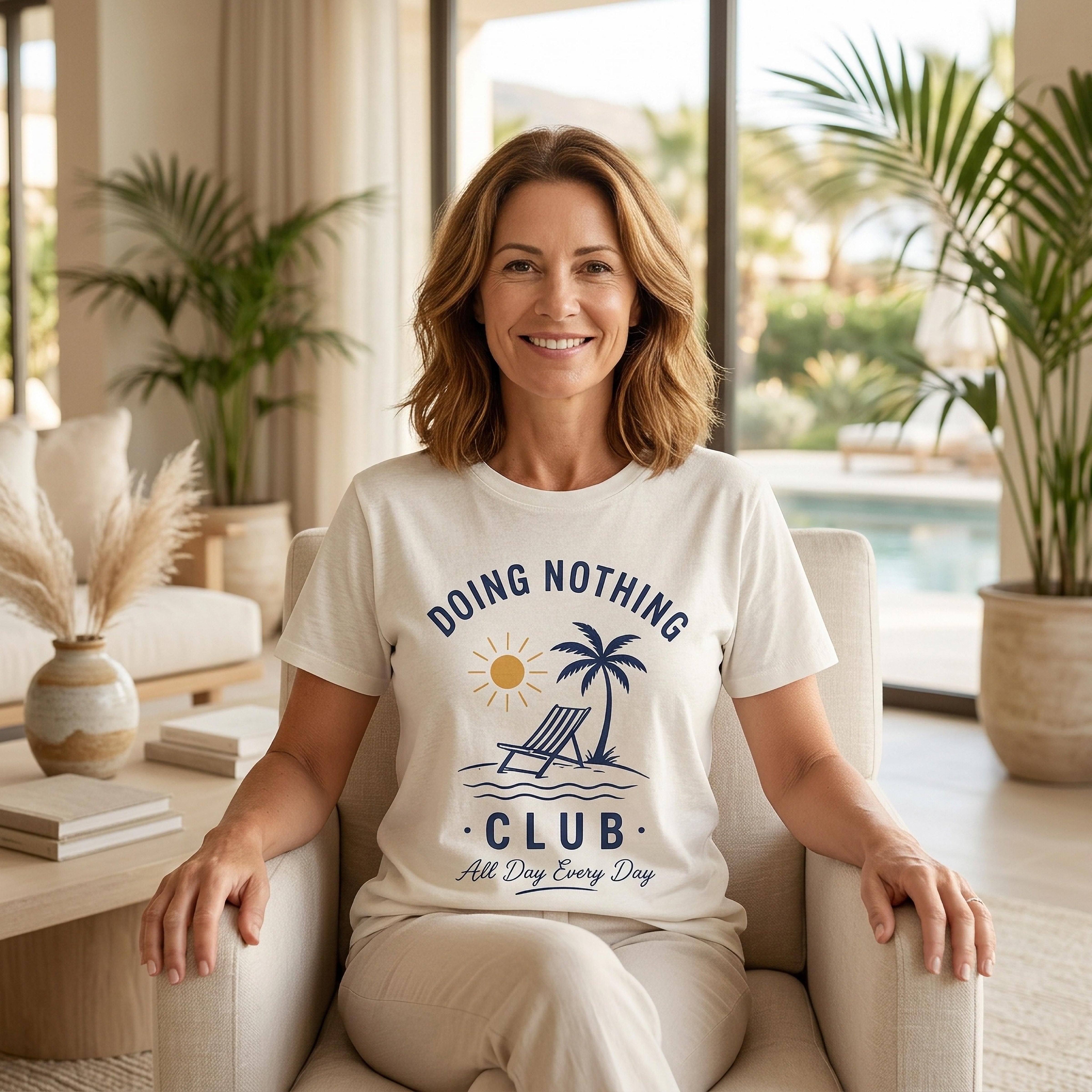 Woman wearing white t-shirt with "Doing Nothing Club" text and palm tree graphic.