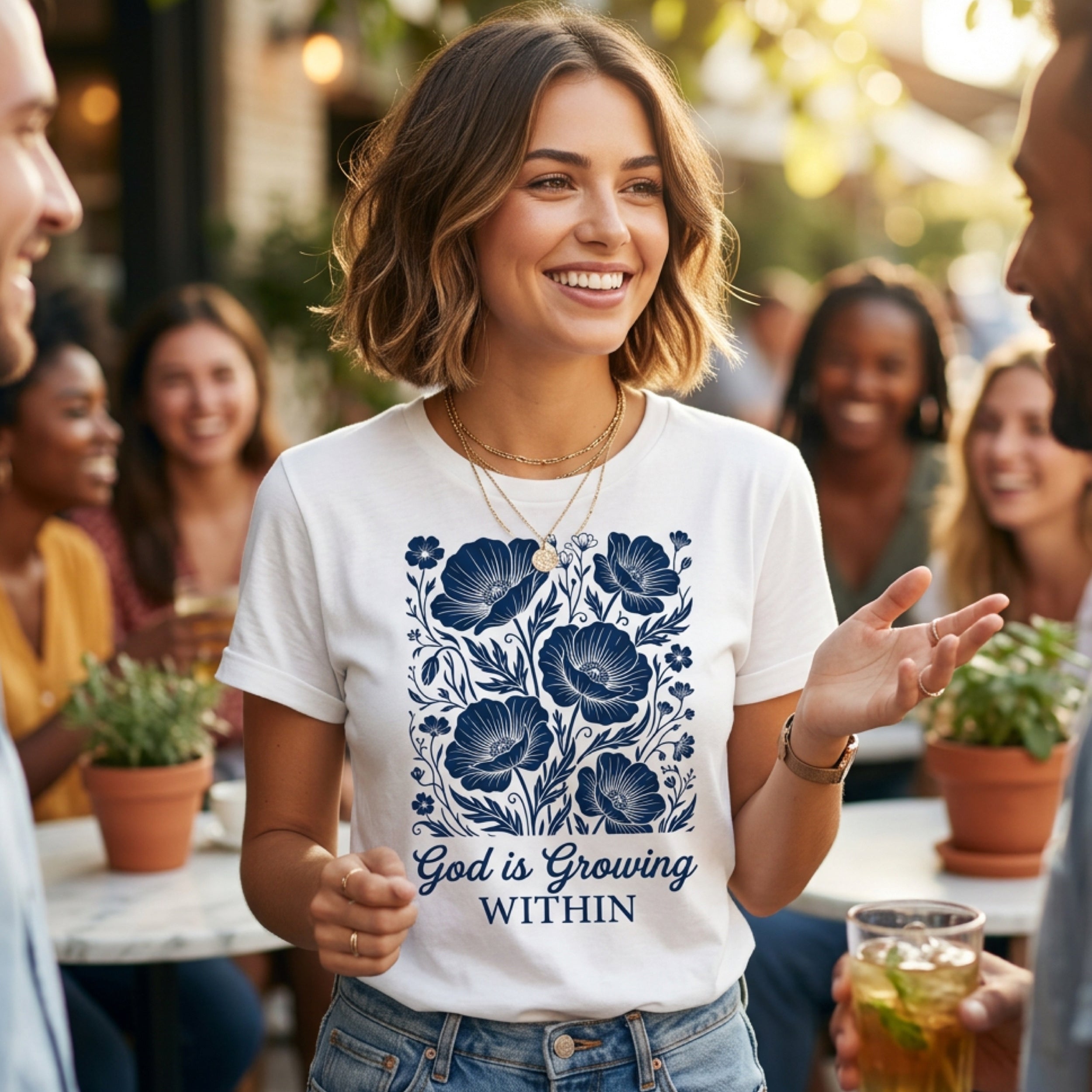 Woman in white t-shirt with blue floral design and text "God is Growing Within".