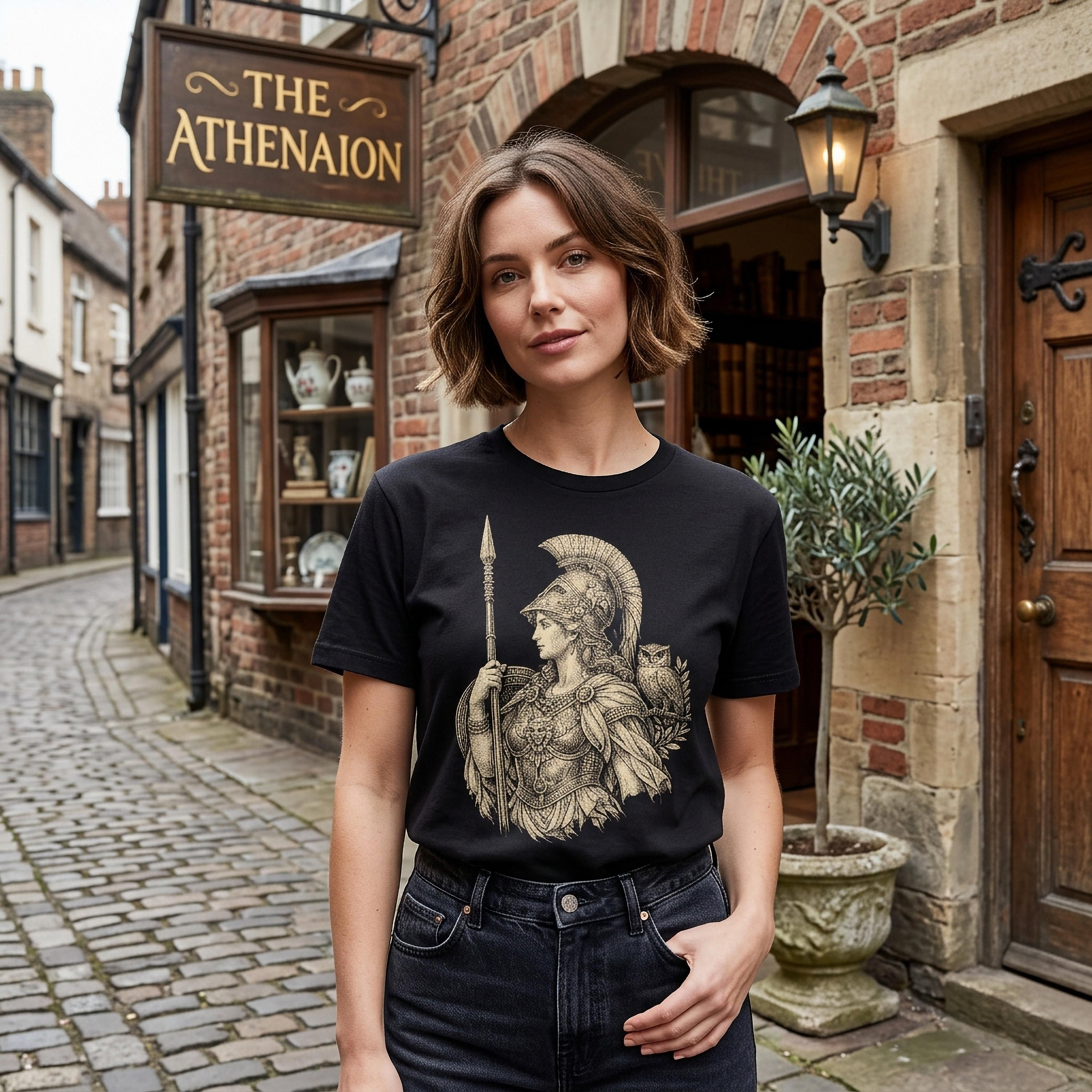 Woman wearing black t-shirt with Athena illustration standing outside The Athenaeum.