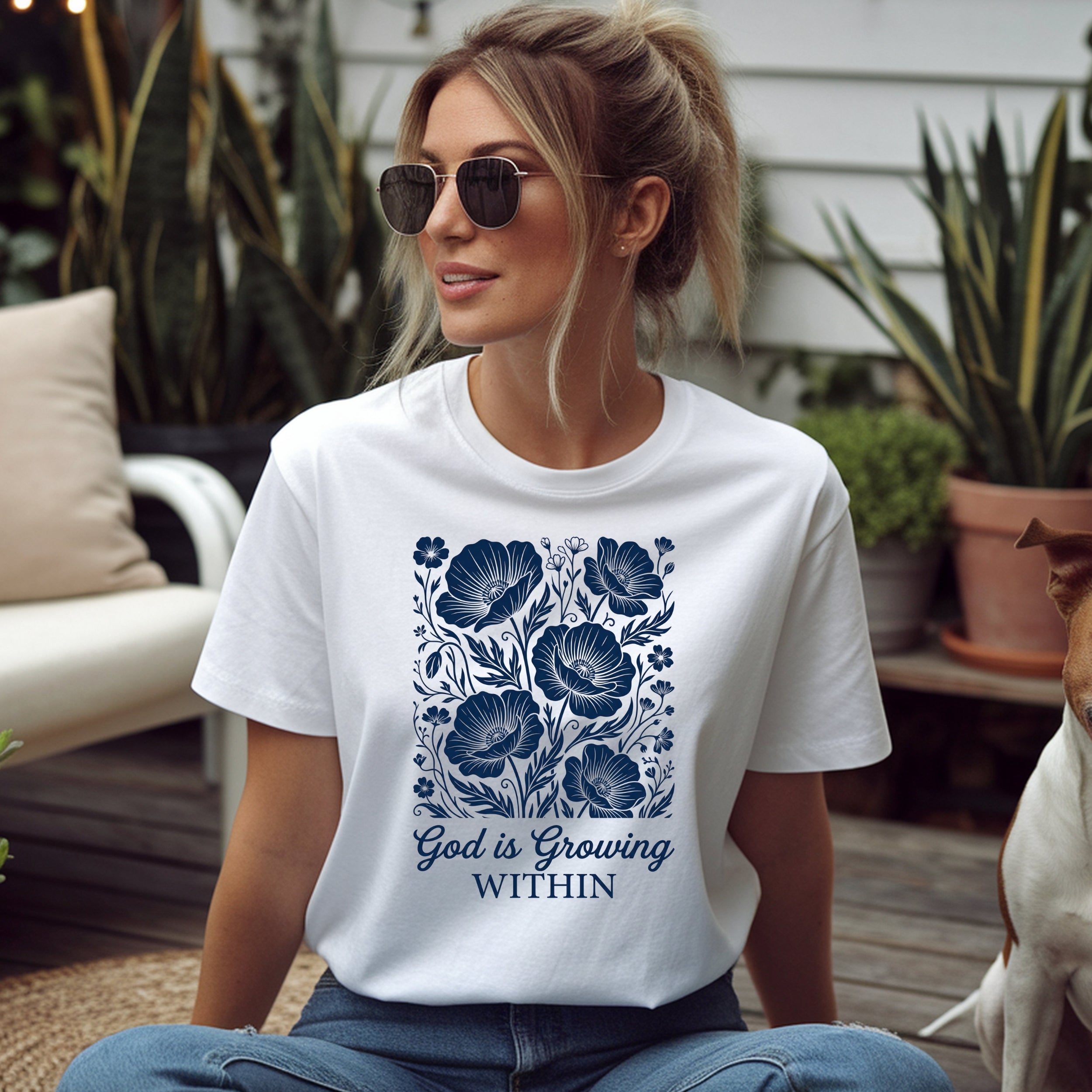 White t-shirt with blue floral design and "GOD IS GROWING WITHIN" text.