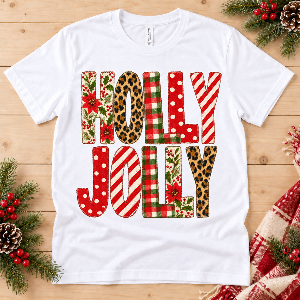 White t-shirt with "HOLLY JOLLY" text featuring festive patterns.