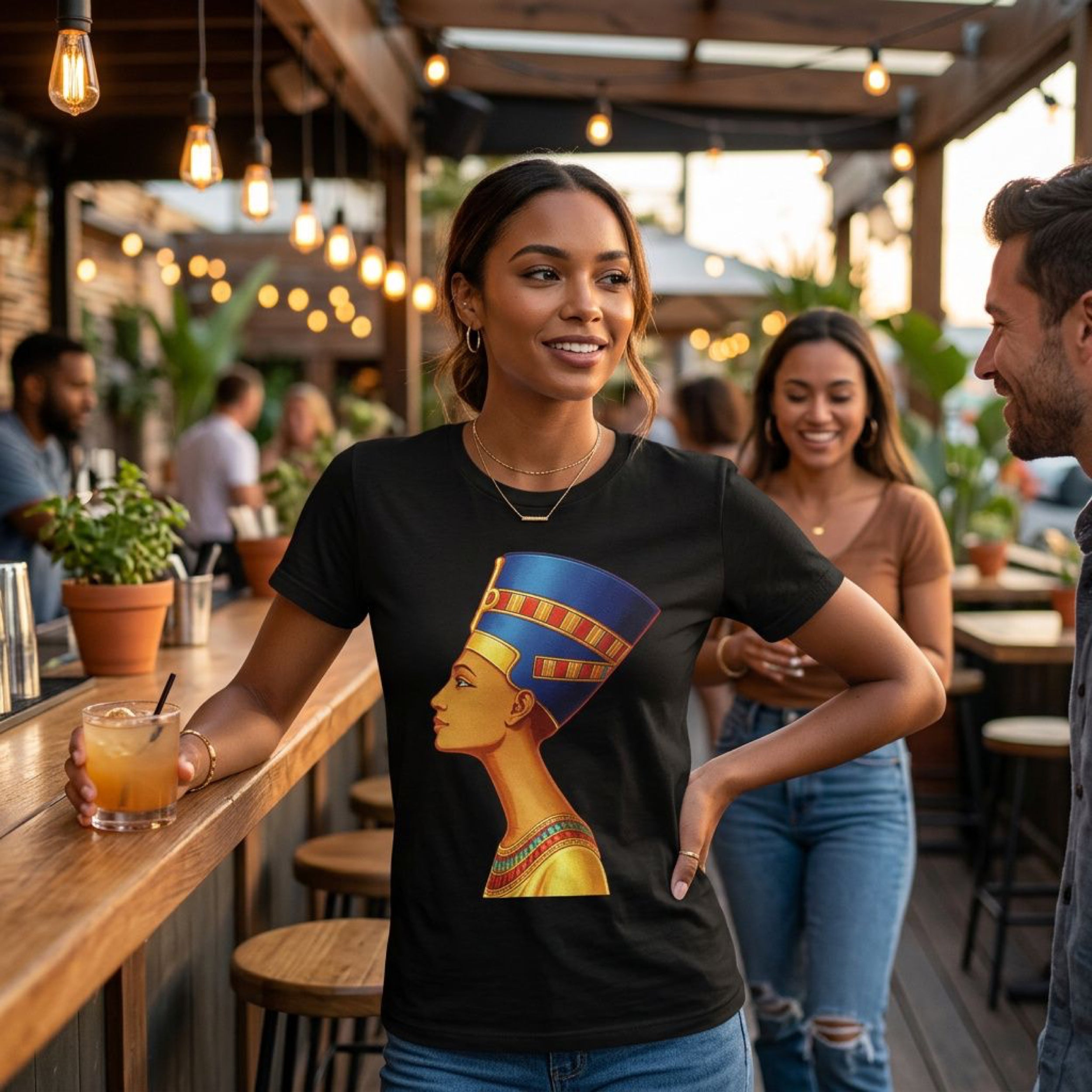 Woman wearing black t-shirt with Nefertiti profile graphic at a bar.