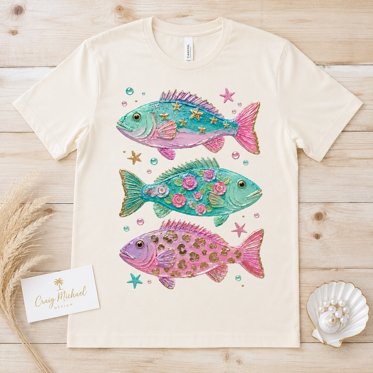 Three decorative fish with textured details and accents on a light-colored t-shirt.