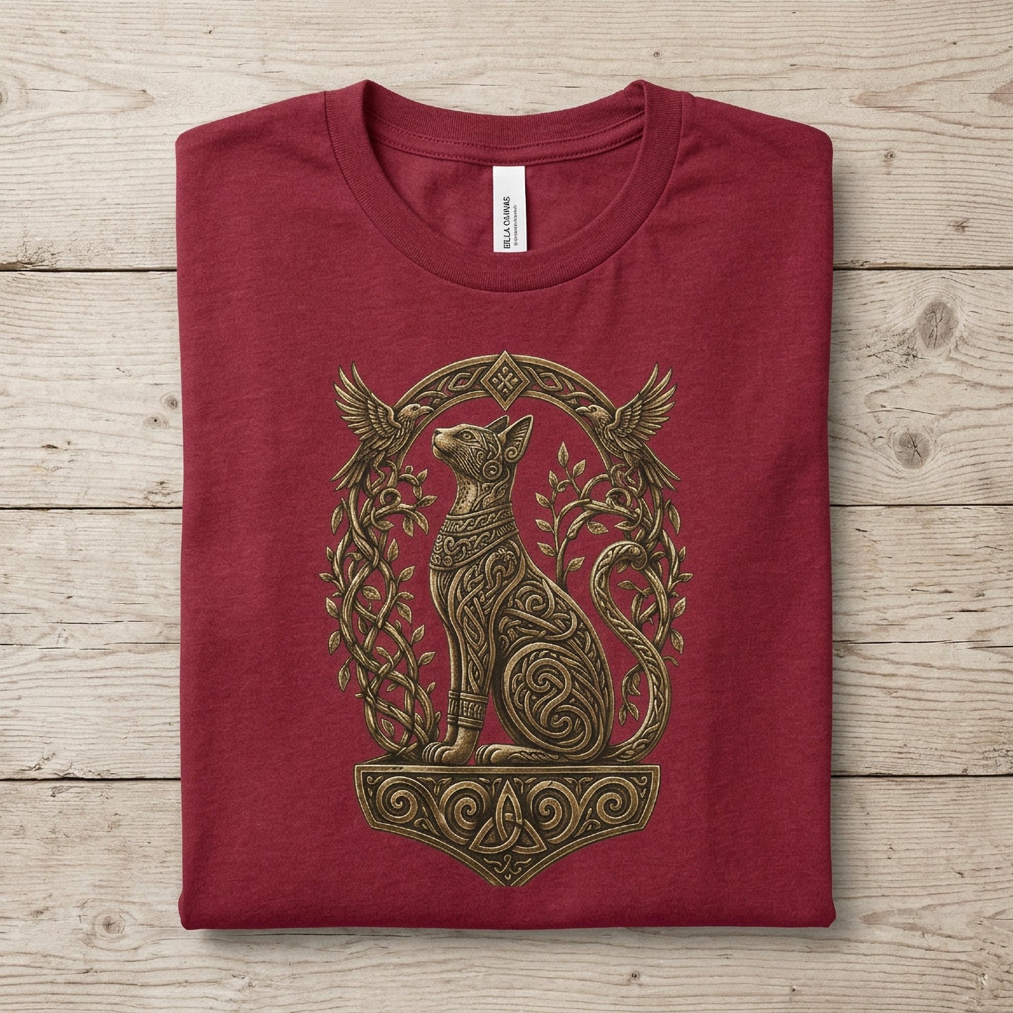 Maroon t-shirt with ornate golden cat and bird design.