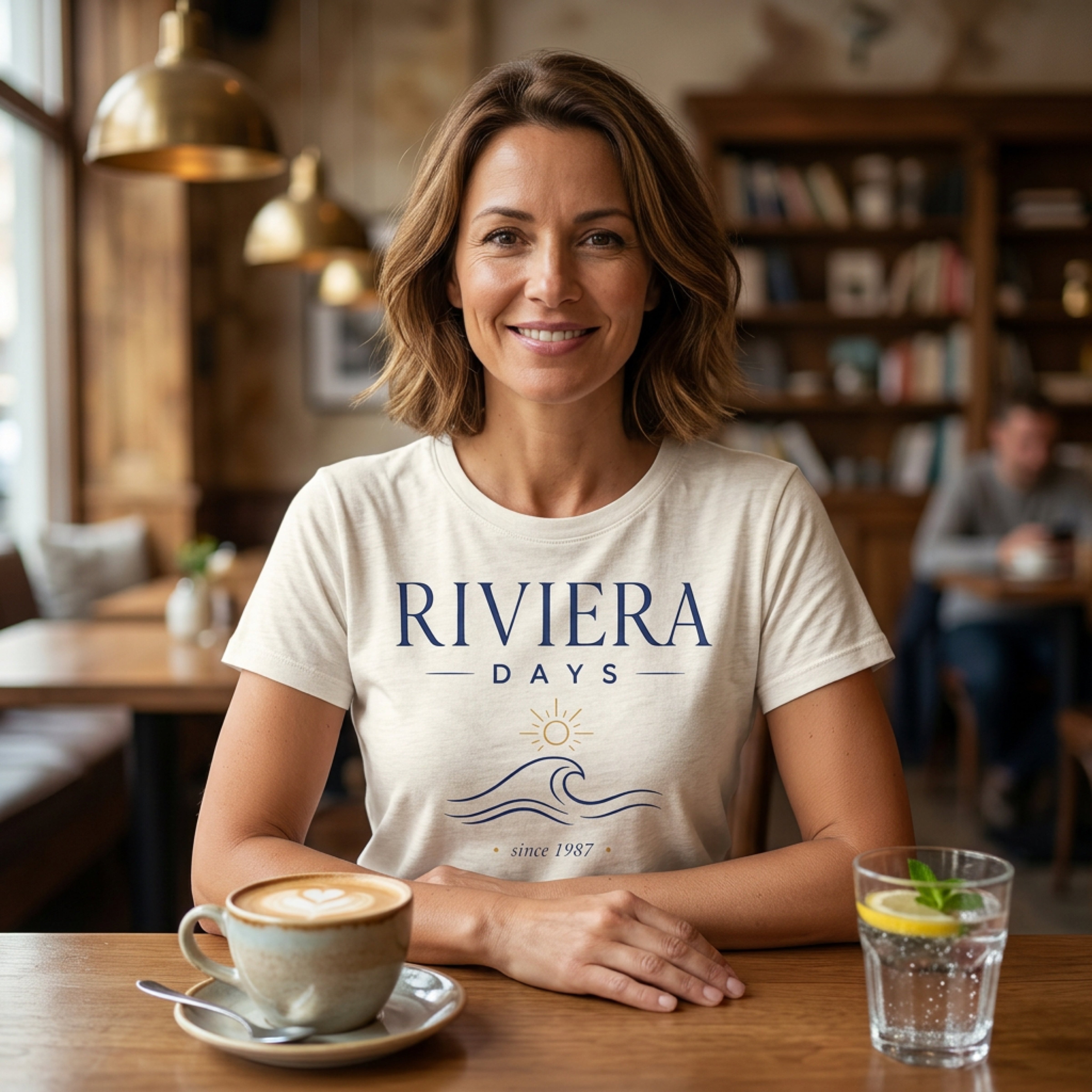 Woman in beige t-shirt with "Riviera Days since 1987" text and wave graphic.