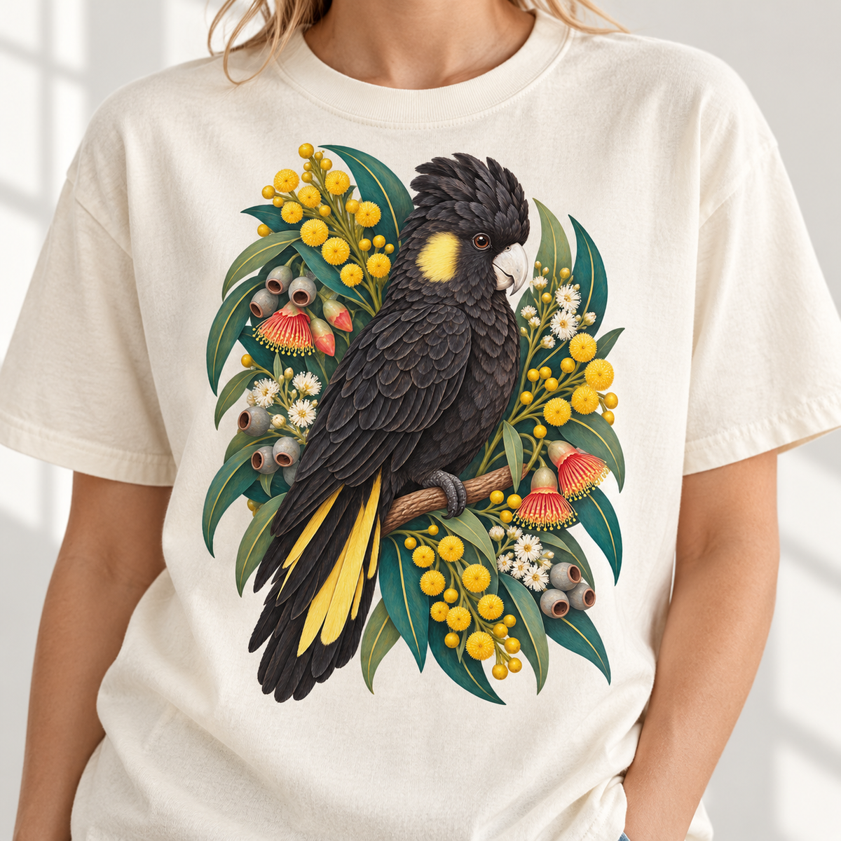 Black cockatoo perched on a branch with yellow wattle blossoms and eucalyptus leaves.