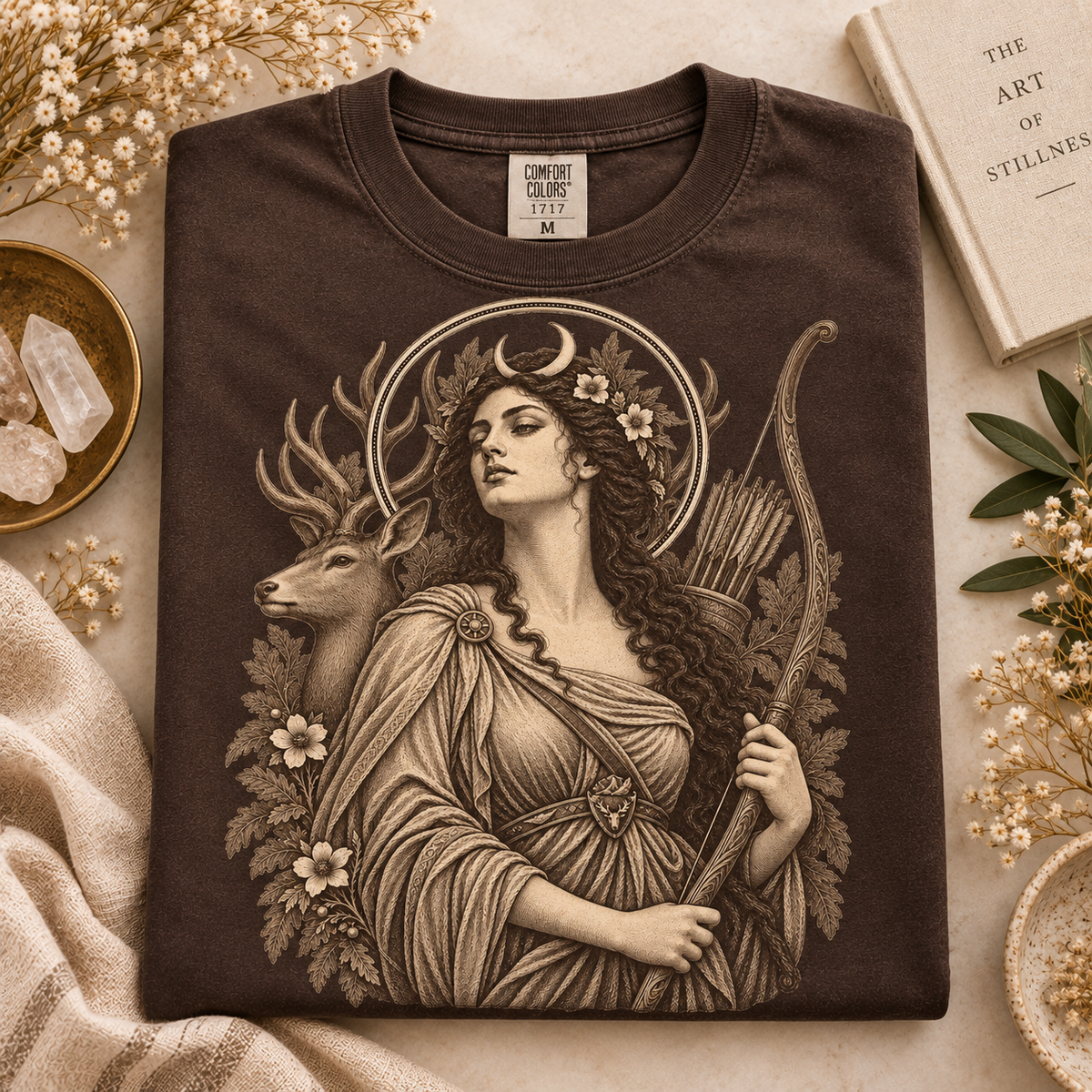 Brown t-shirt featuring a goddess with a bow, arrows, and a deer.