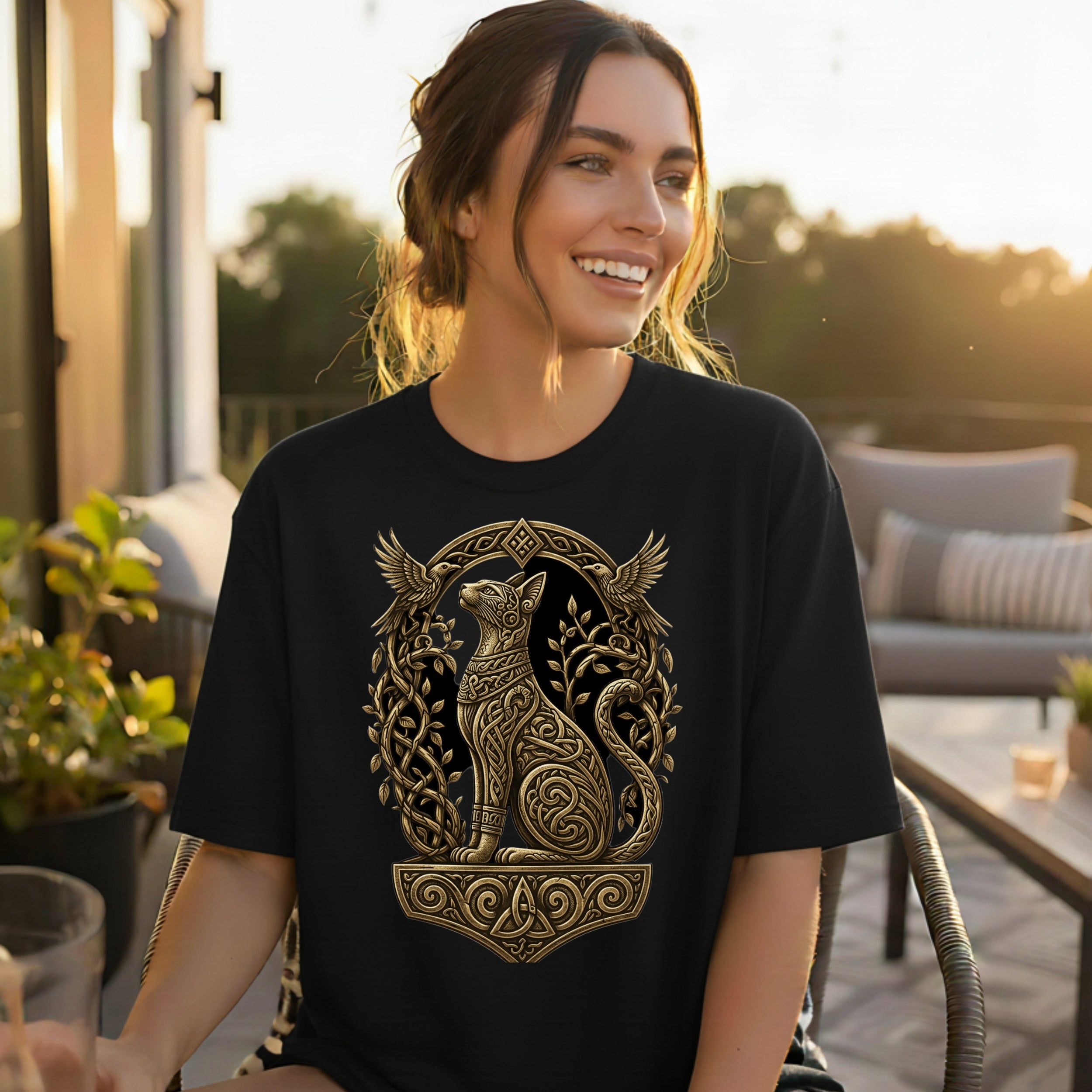 Black t-shirt with ornate golden cat and bird design on chest.