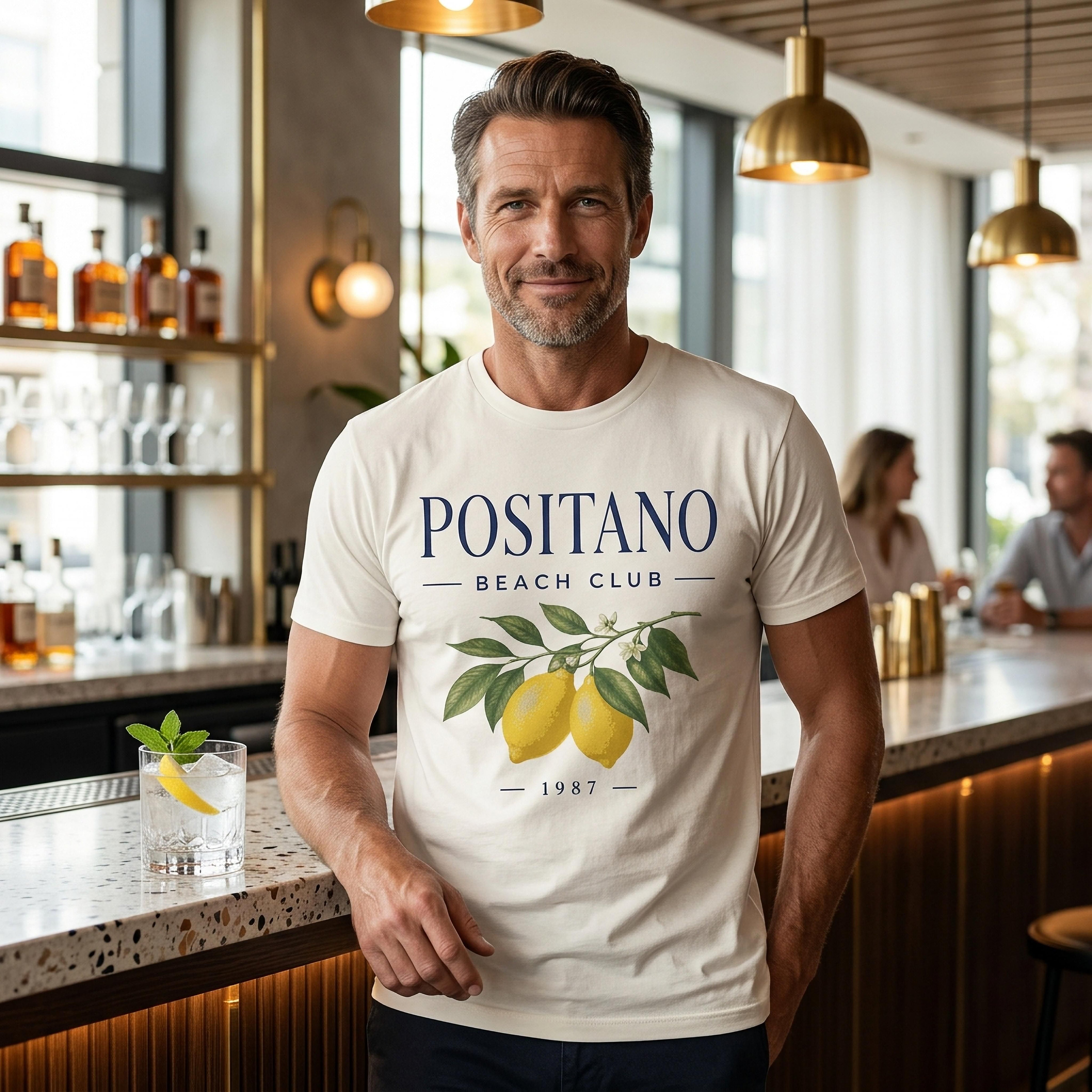 Man wearing white t-shirt with "POSITANO BEACH CLUB 1987" and lemon graphic.