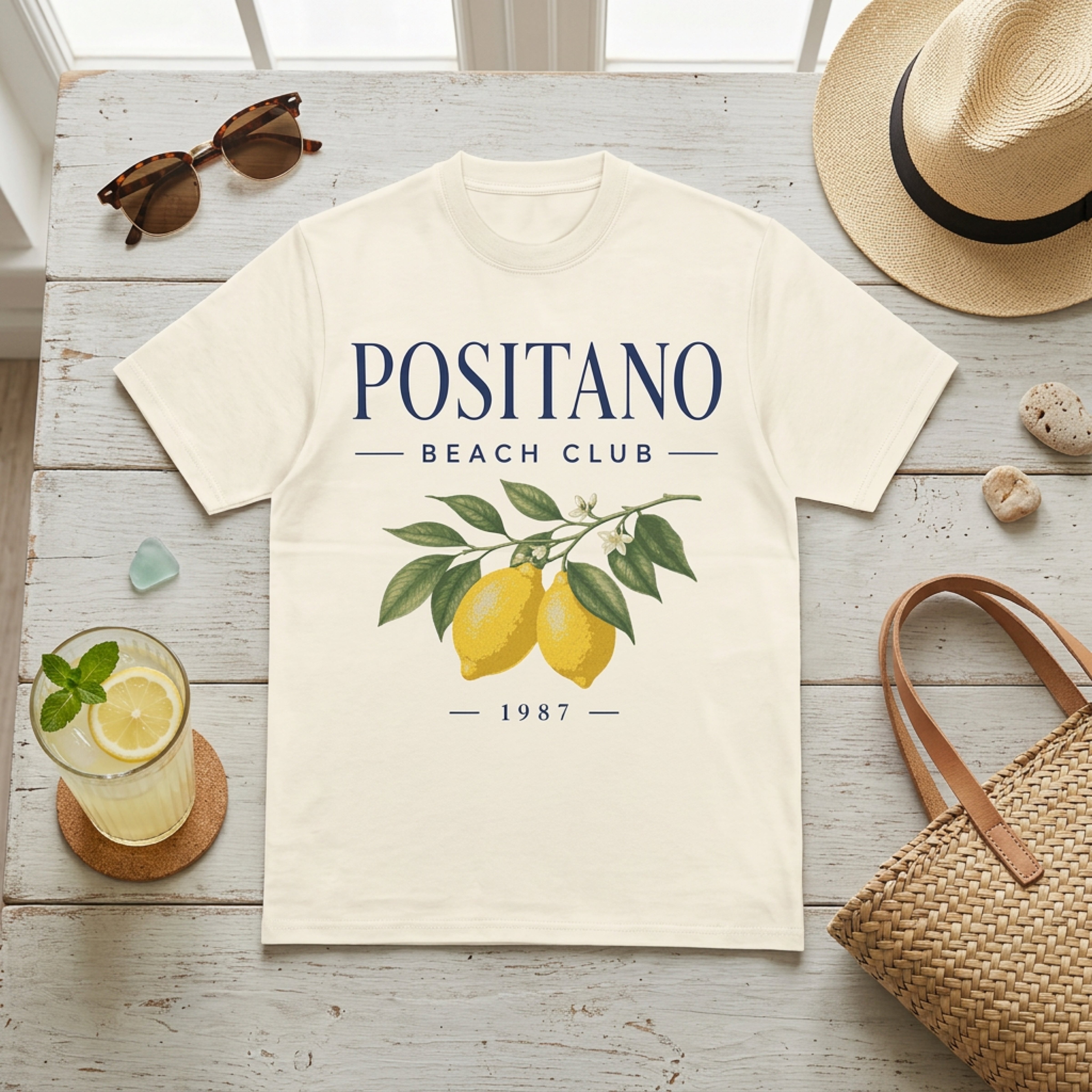 Cream t-shirt with "Positano Beach Club 1987" and lemon graphic.