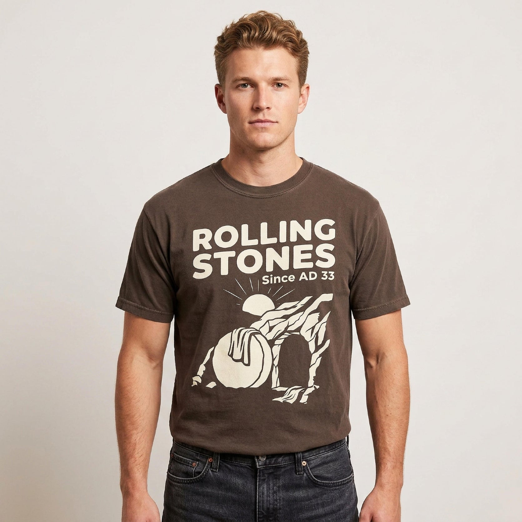 Man wearing brown Rolling Stones Since AD 33 t-shirt with sun graphic.