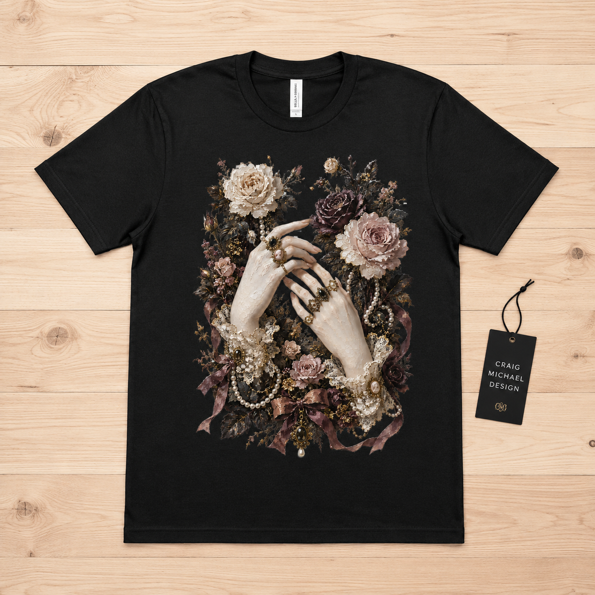 Black t-shirt with a floral artwork featuring hands adorned with jewelry and pearls.