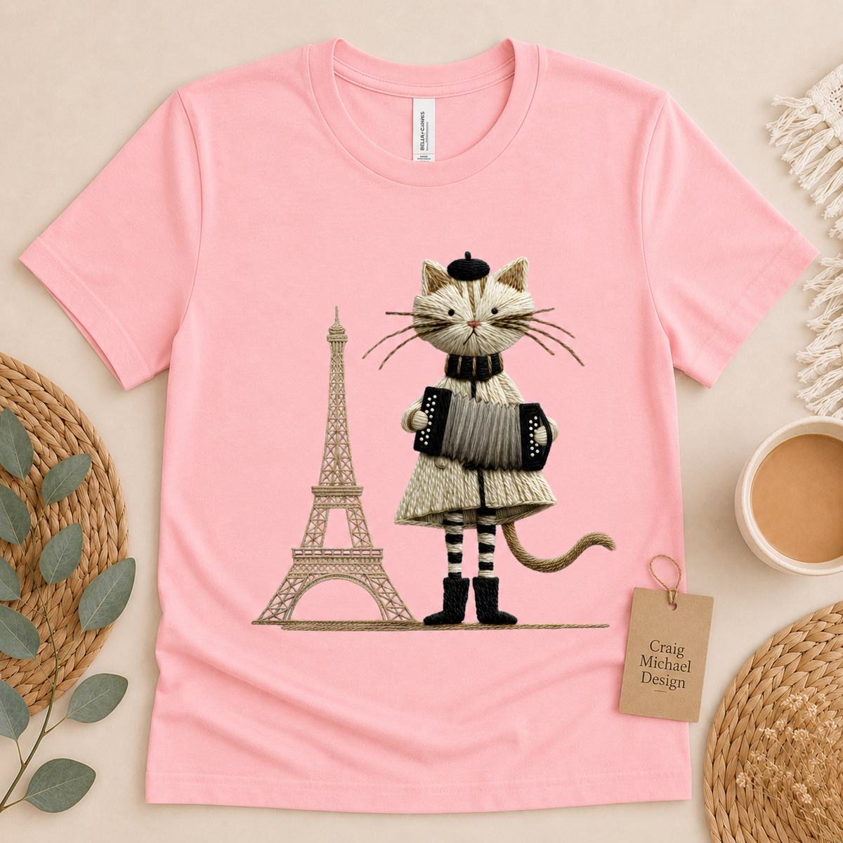 Pink t-shirt with embroidered cat in beret playing accordion by Eiffel Tower.
