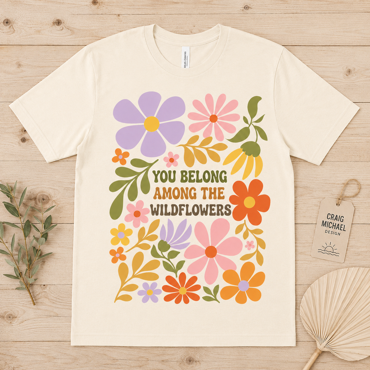 Cream t-shirt with retro floral design and text "You Belong Among the Wildflowers."
