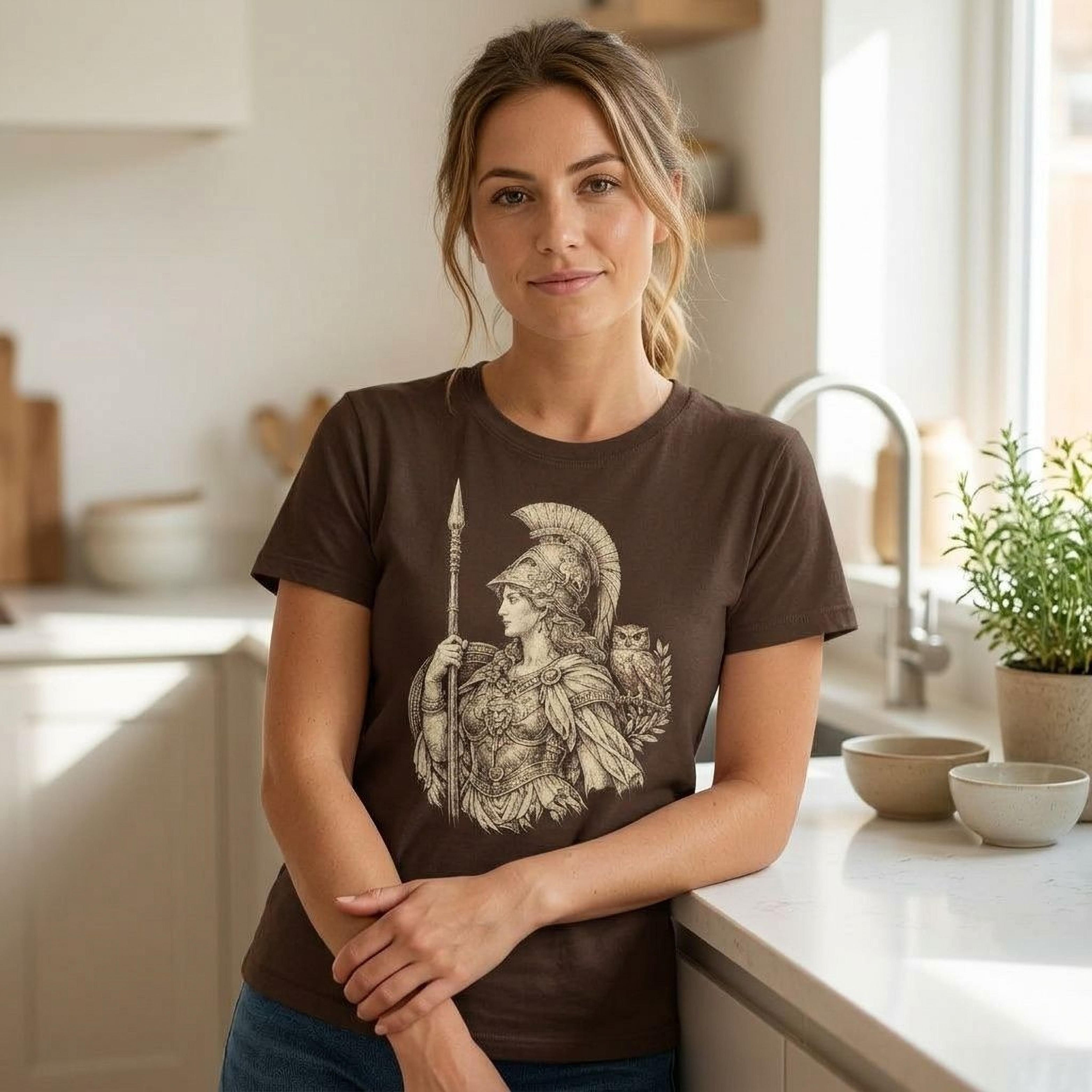 Woman in brown t-shirt with Athena and owl graphic.