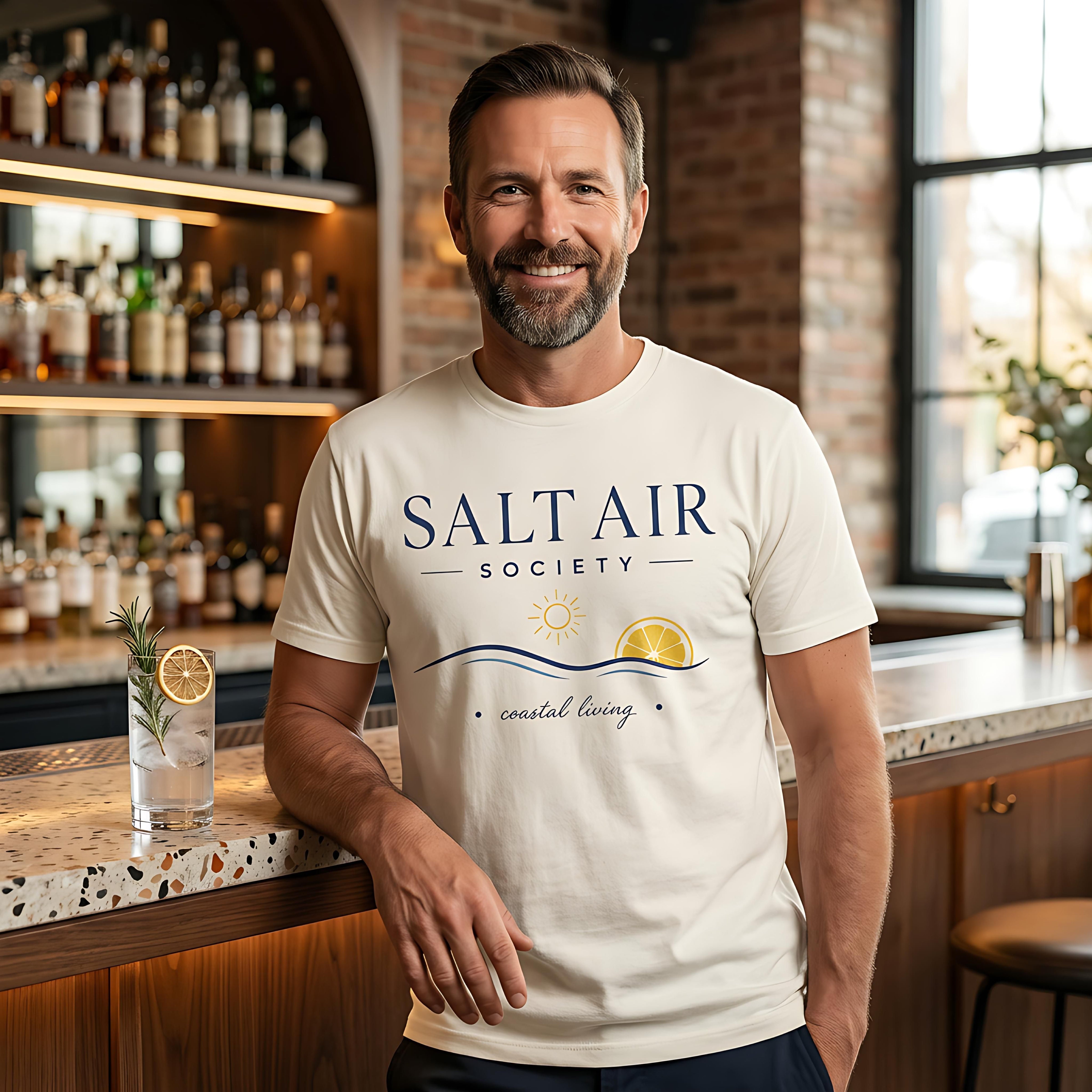 Man wearing "Salt Air Society" t-shirt with sun and waves logo and text.