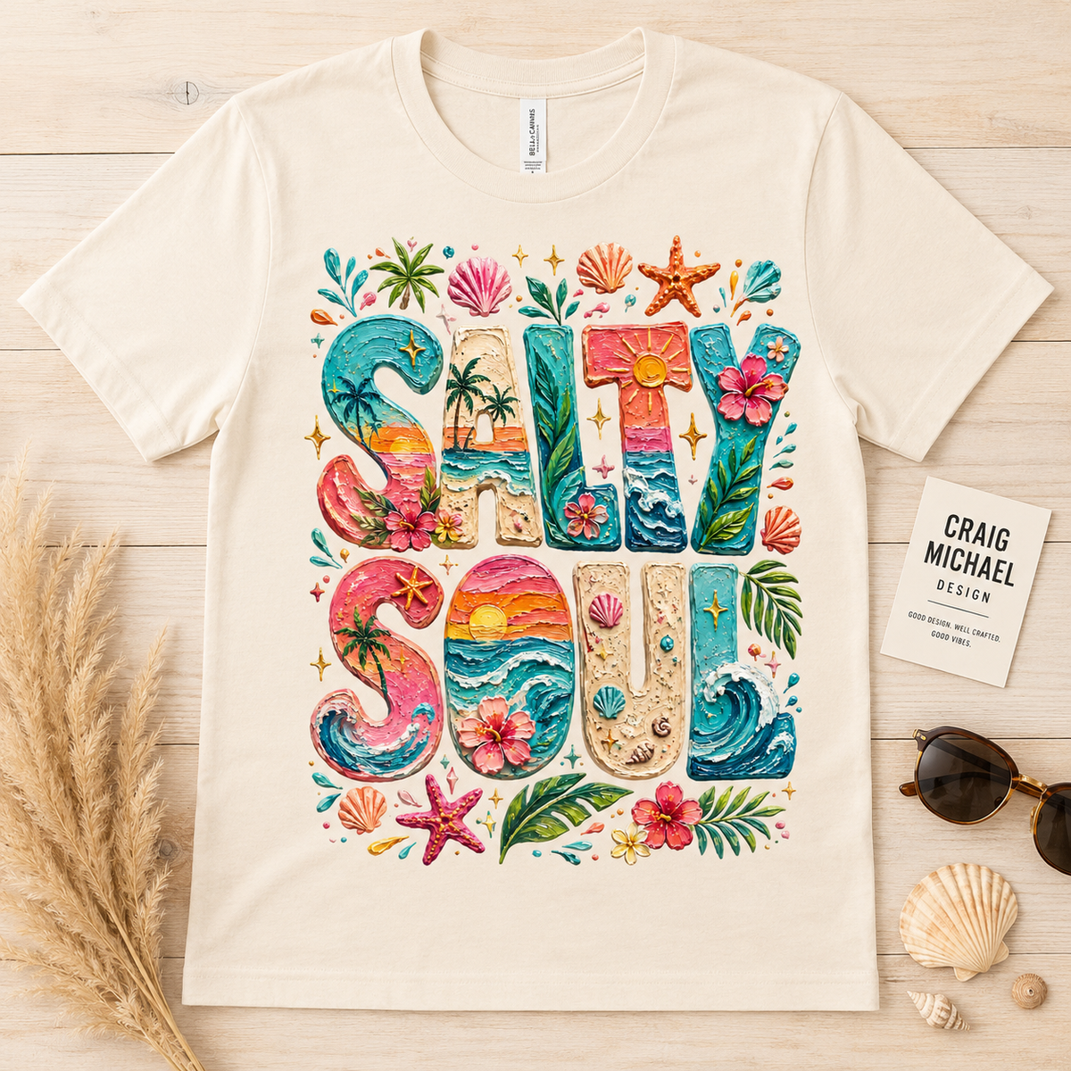 Cream t-shirt with "Salty Soul" beach themed graphic and tropical elements.