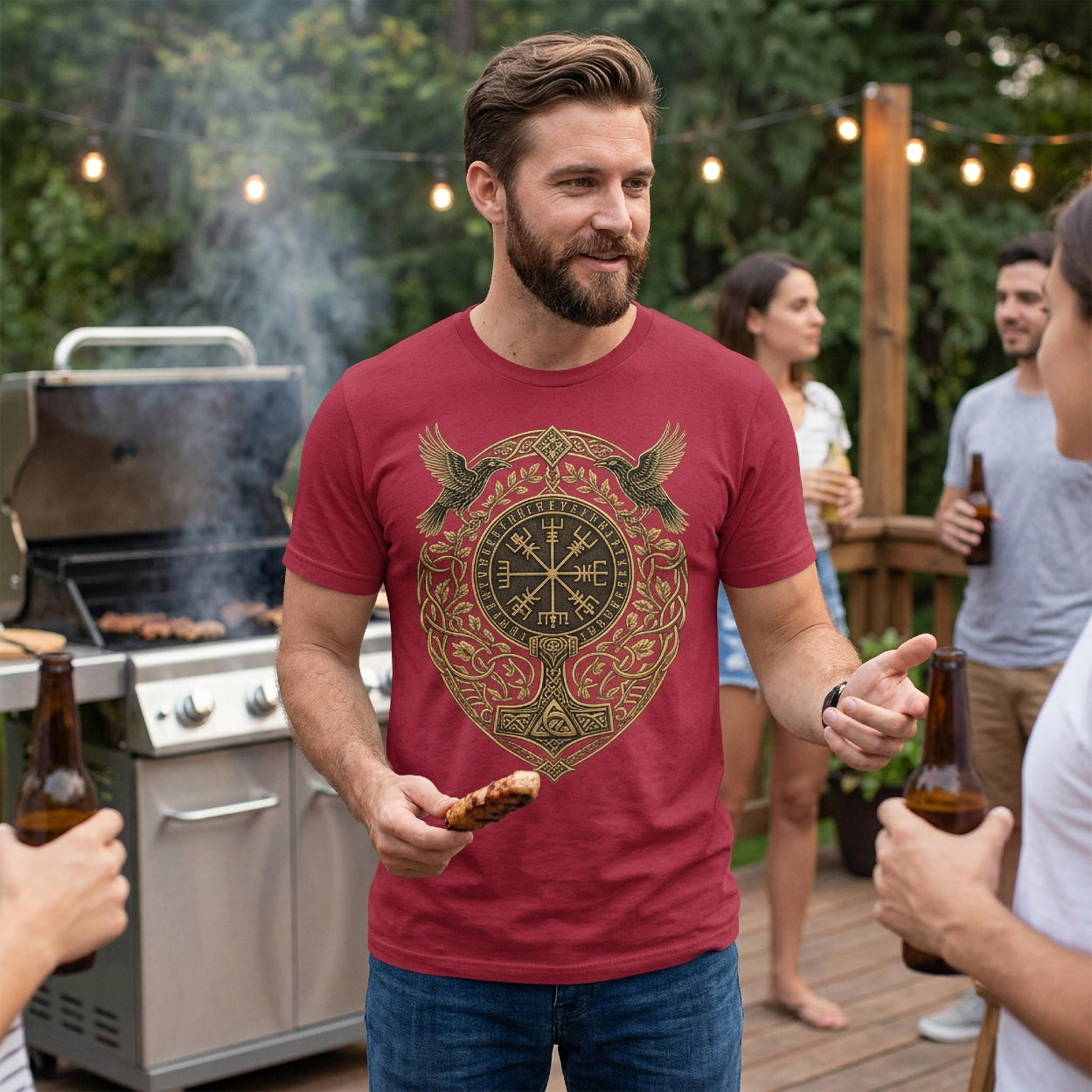 Man in burgundy t-shirt with Viking-inspired gold design, holding food.