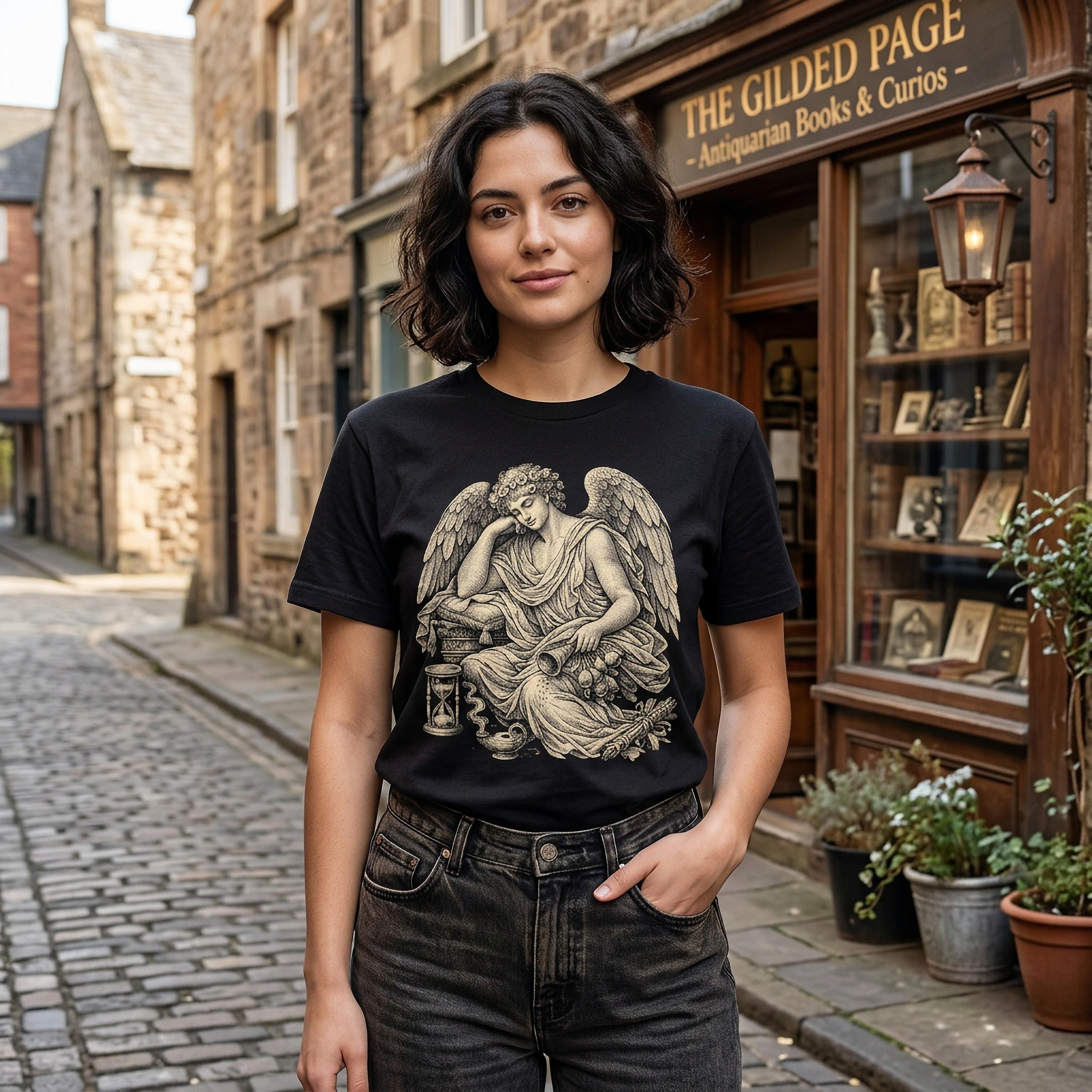 Woman wearing black t-shirt with angel and hourglass graphic, standing on street.
