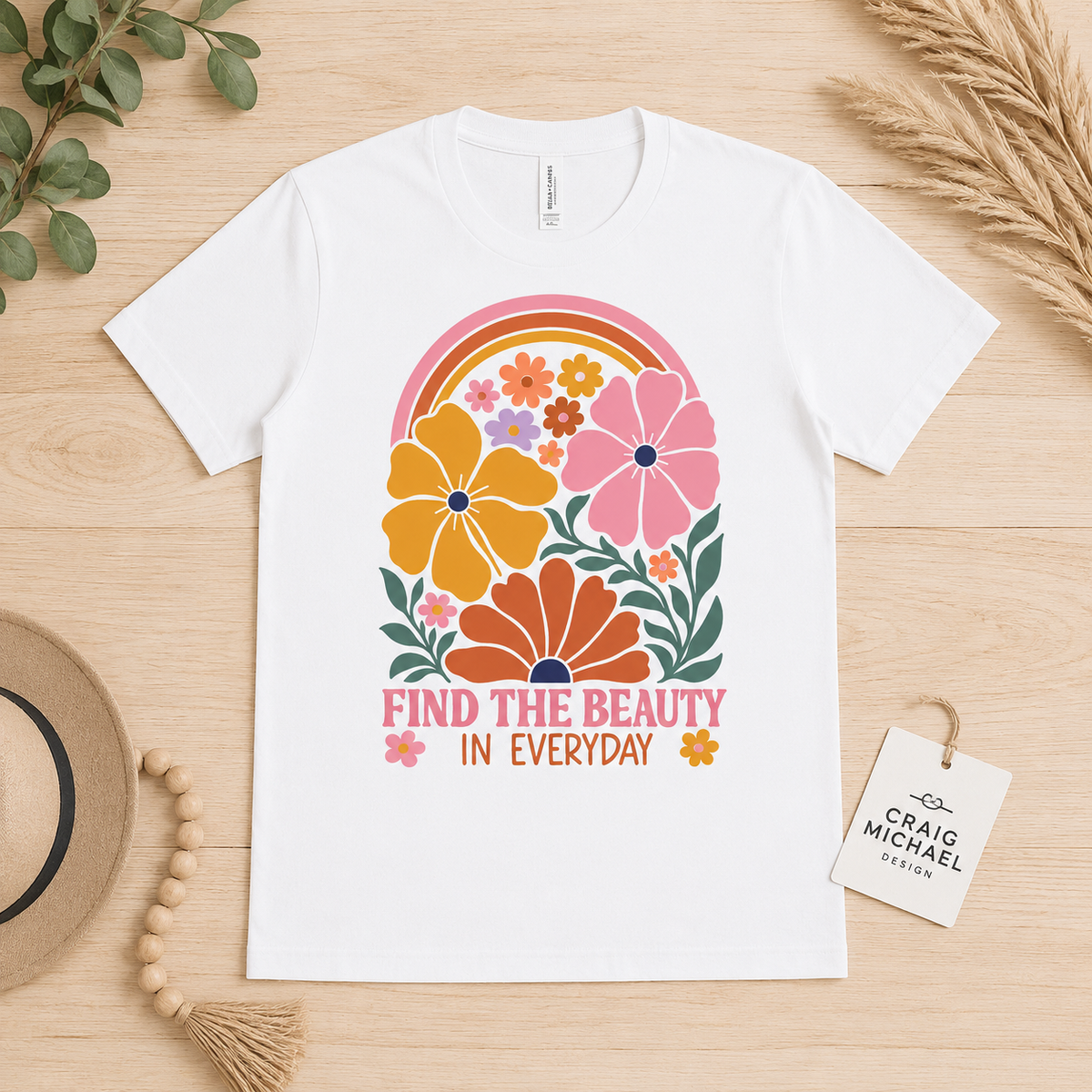 White t-shirt with colorful floral rainbow graphic and text "FIND THE BEAUTY IN EVERYDAY".