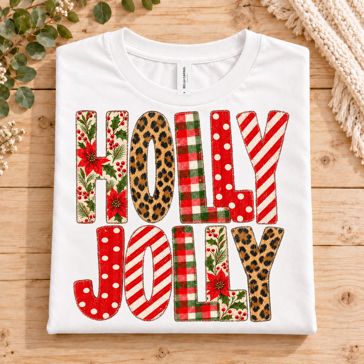White t-shirt with "HOLLY JOLLY" text in festive patterns.