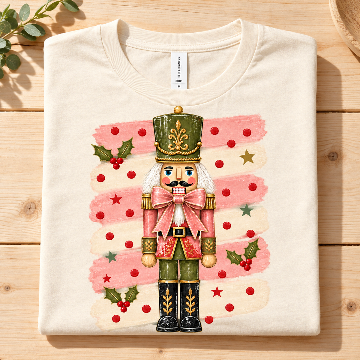Cream t-shirt with a nutcracker graphic featuring pink brushstrokes and red dots.