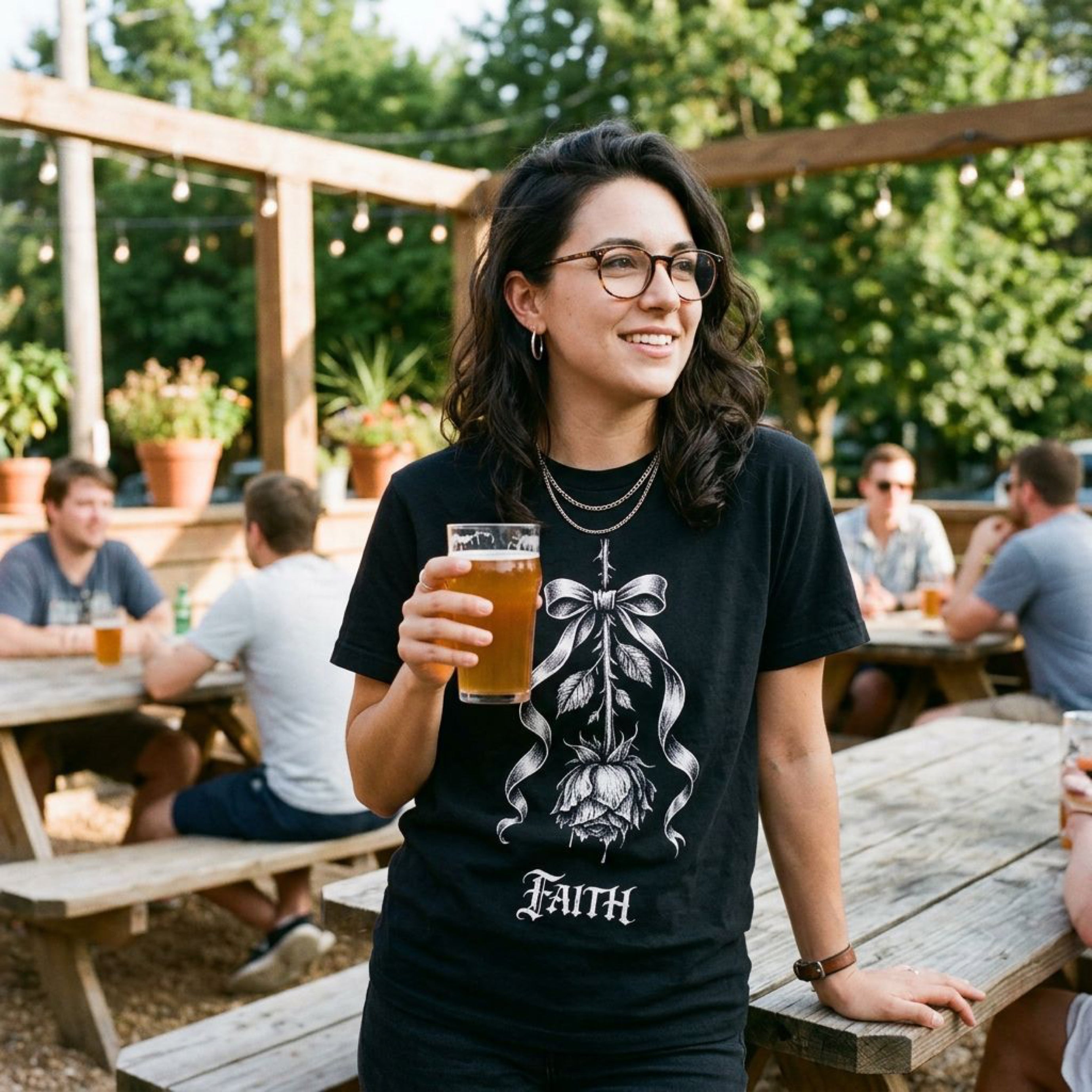 Woman in black t-shirt holding a beer, with a rose and bow design.
