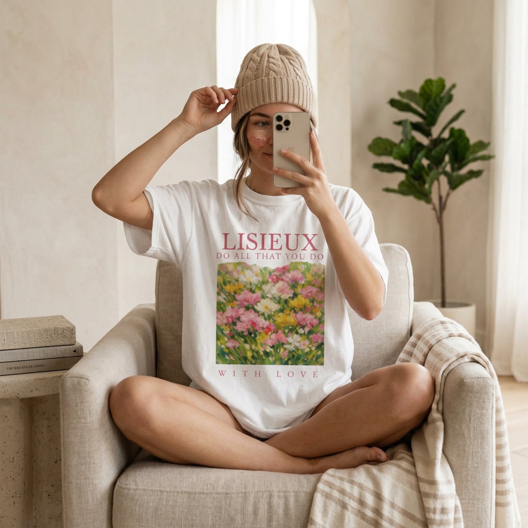 Woman wearing a white t-shirt with floral artwork and text, holding a phone.