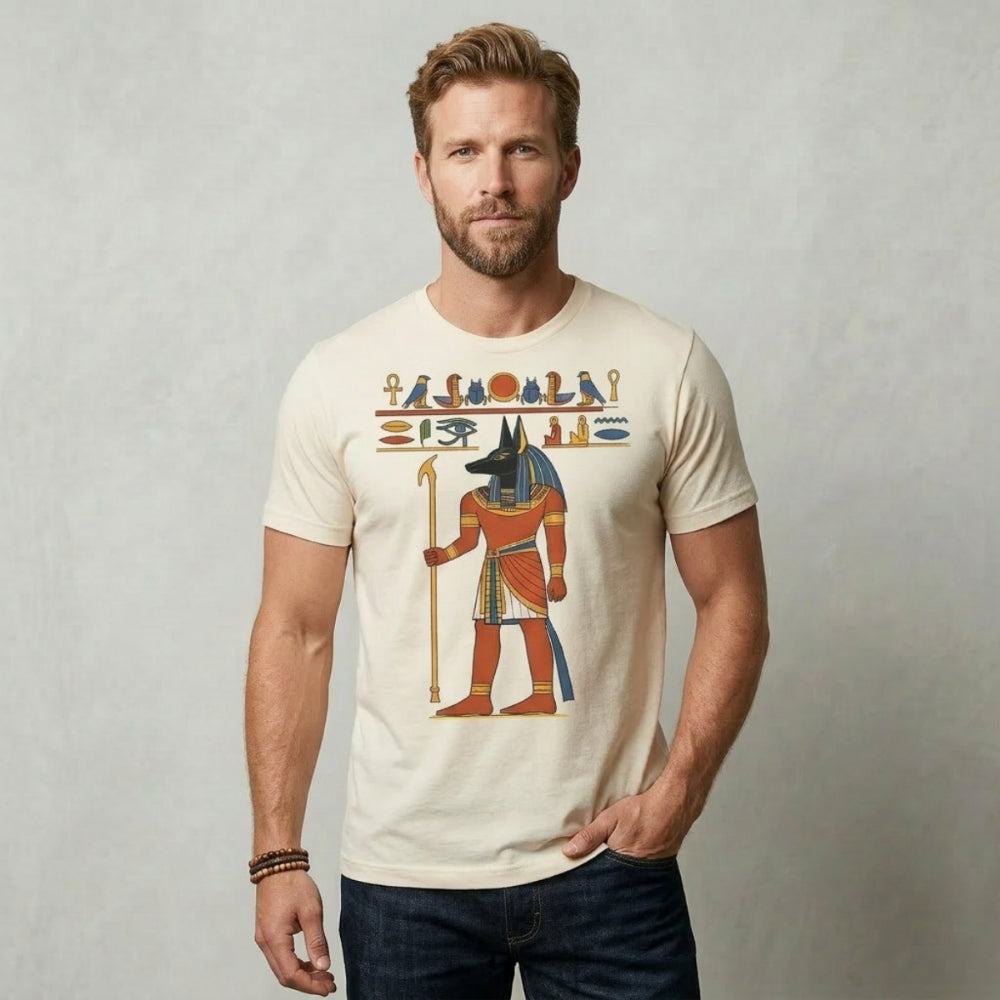 Man wearing a cream t-shirt with an Anubis graphic and Egyptian hieroglyphs.