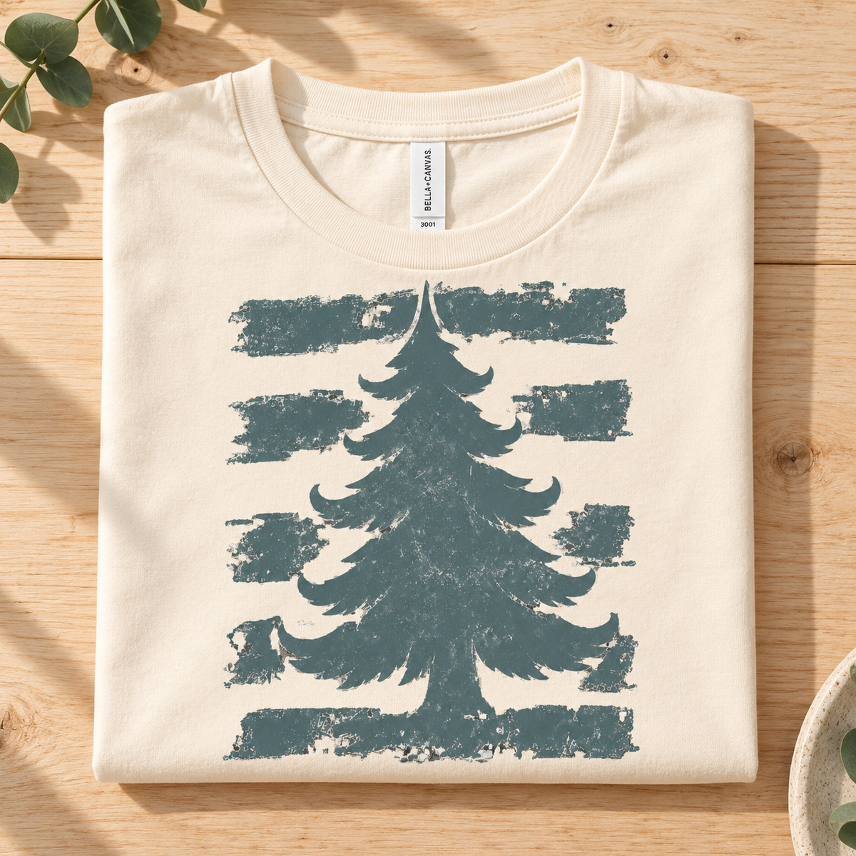Cream t-shirt with distressed pine tree graphic and horizontal brush strokes.