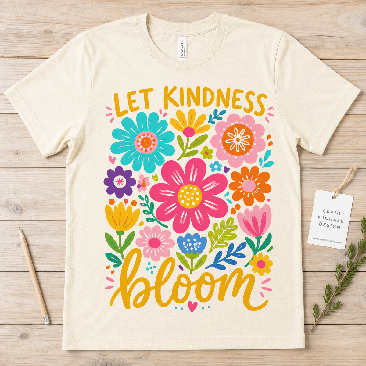 Cream t-shirt with "Let Kindness Bloom" and colorful floral graphics.