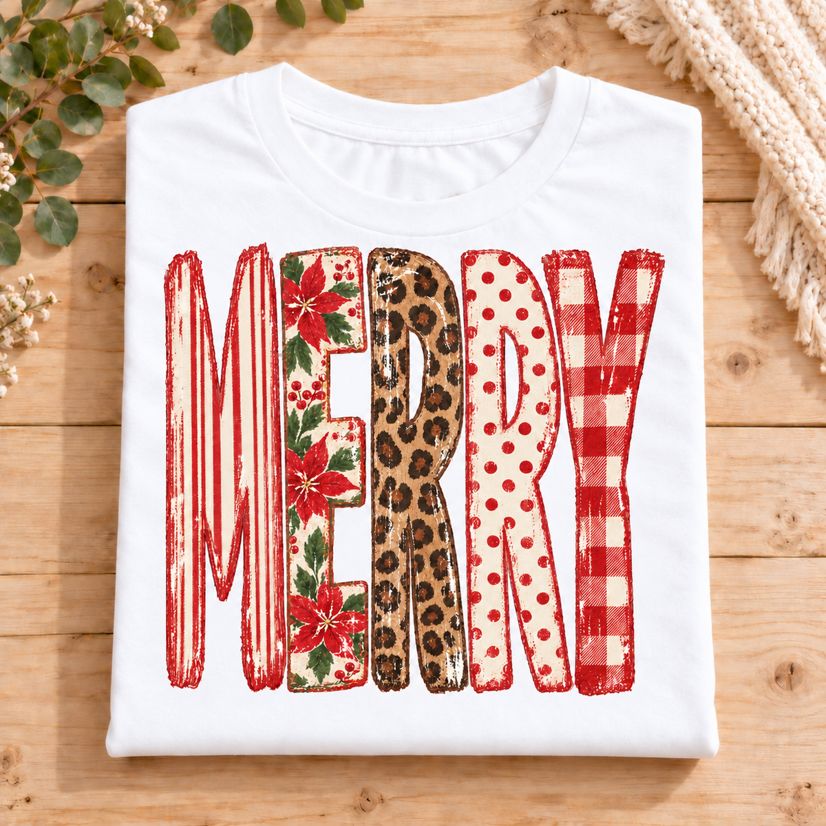 Merry Christmas Leopard Patchwork on a White Bella+Canvas T-shirt folded in a neat square on light timber